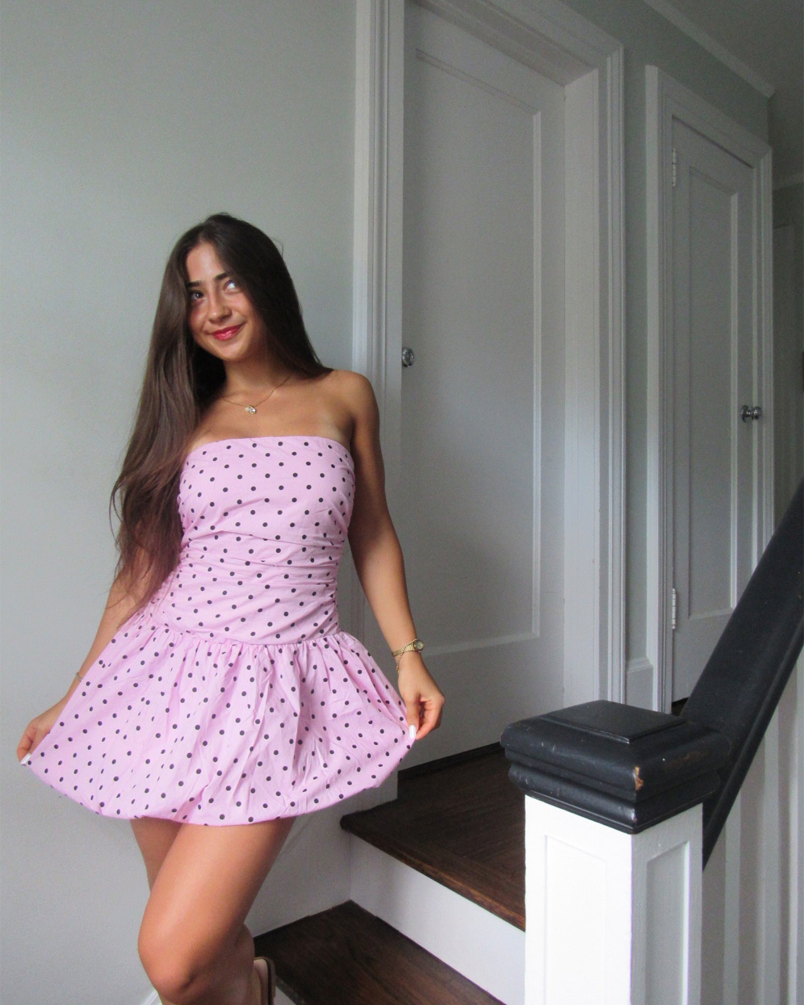 Front view of pink strapless mini dress with bubble skirt worn at a rooftop party.