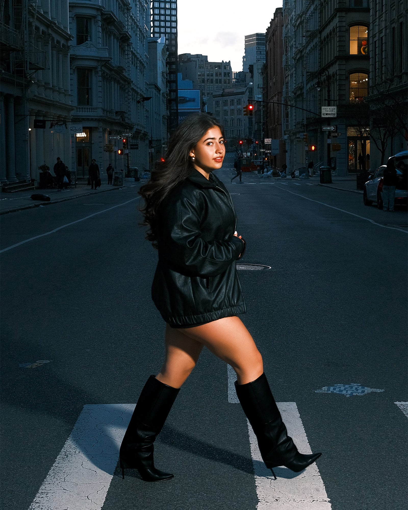 On-foot photo of black leather boots worn in a city night setting