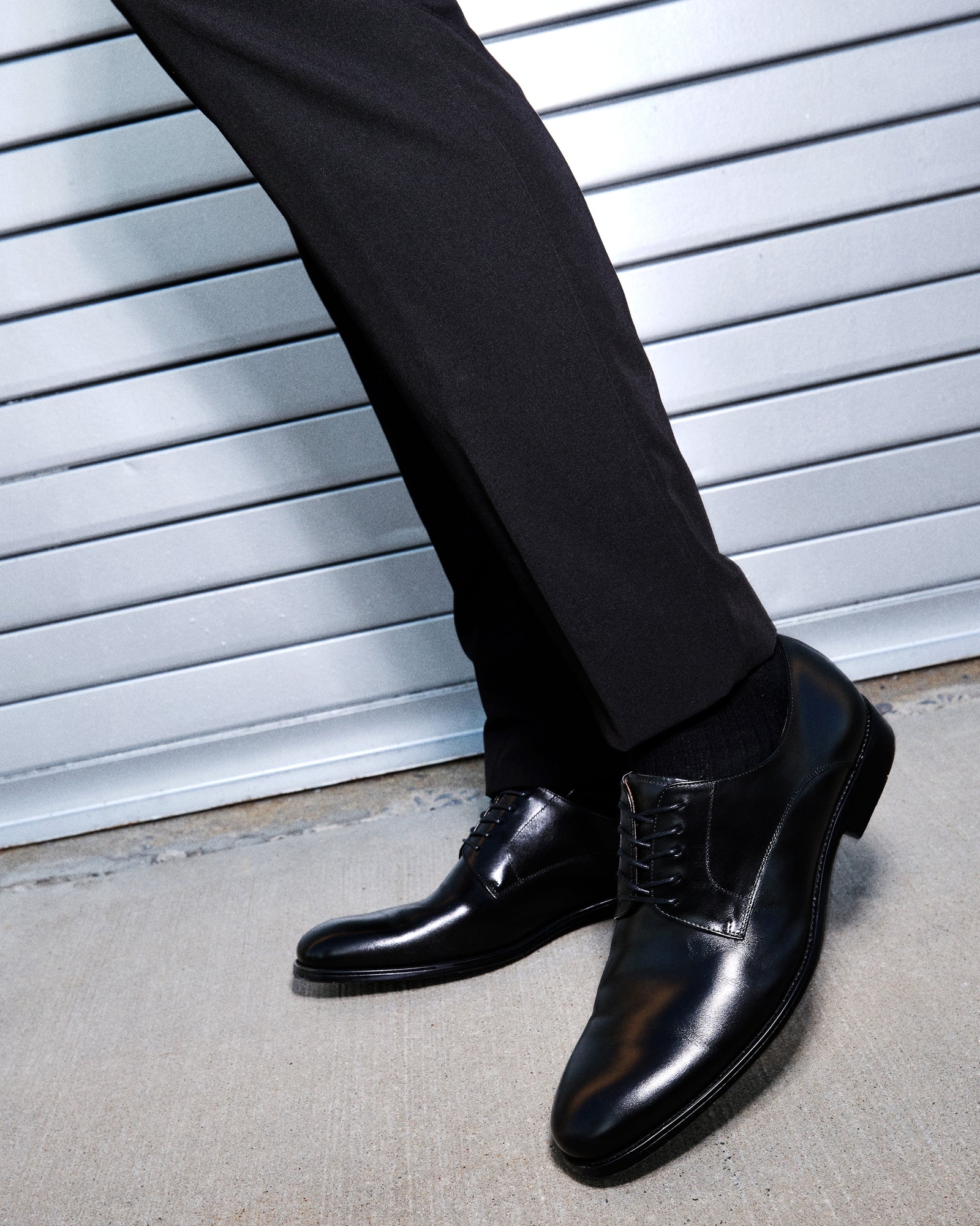 Side view of mens black leather derby shoes highlighting the low-profile silhouette