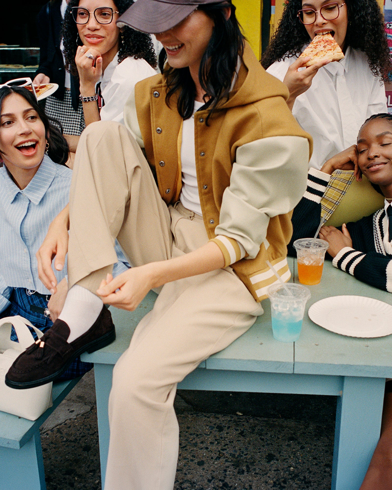 Close-up of the hooded varsity jacket with mustard color and leather sleeves