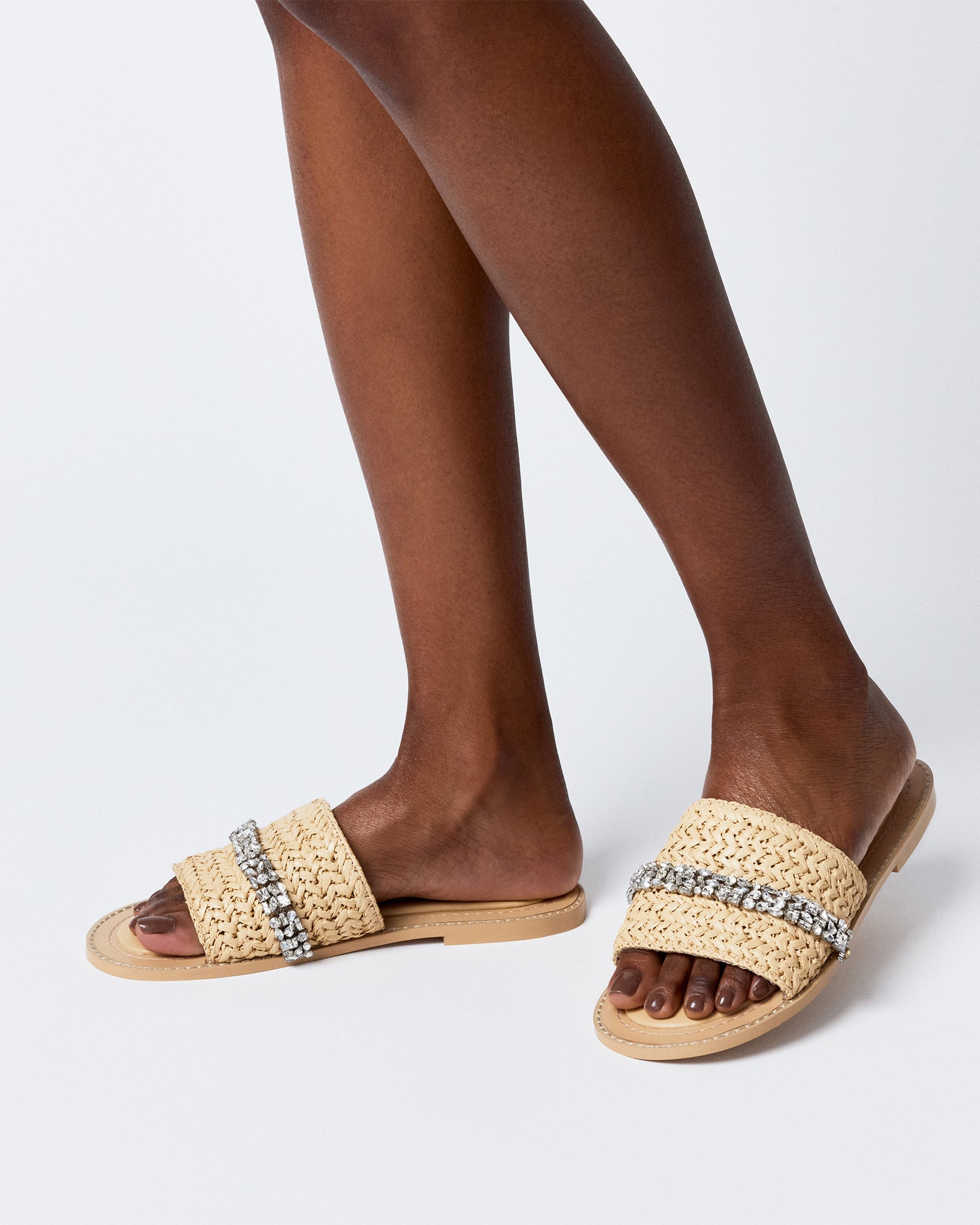 Model wearing black raffia sandals for a stylish day at the beach or evening event