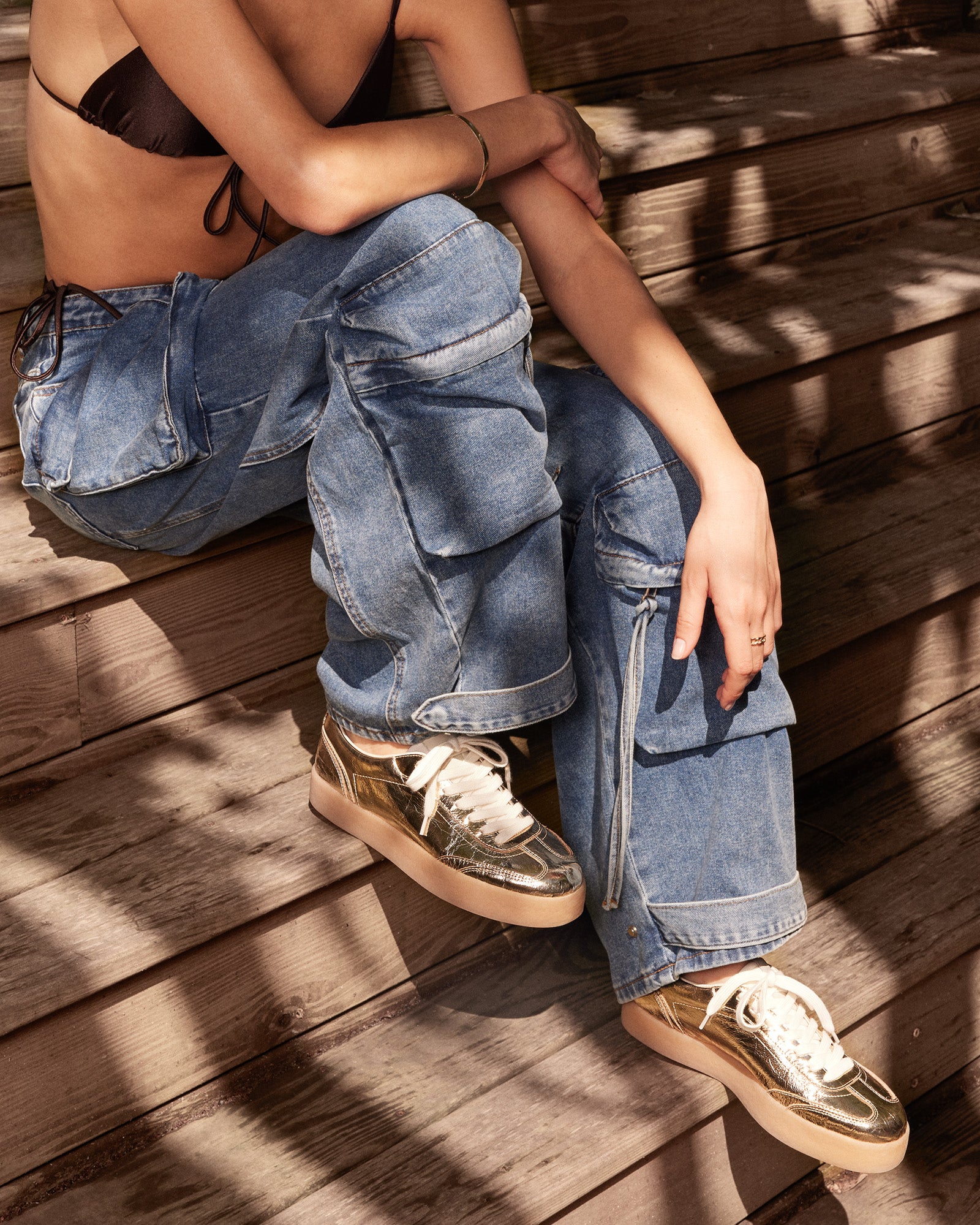 Side view of TUX Gold low-top sneakers showing sleek leather finish and gold details