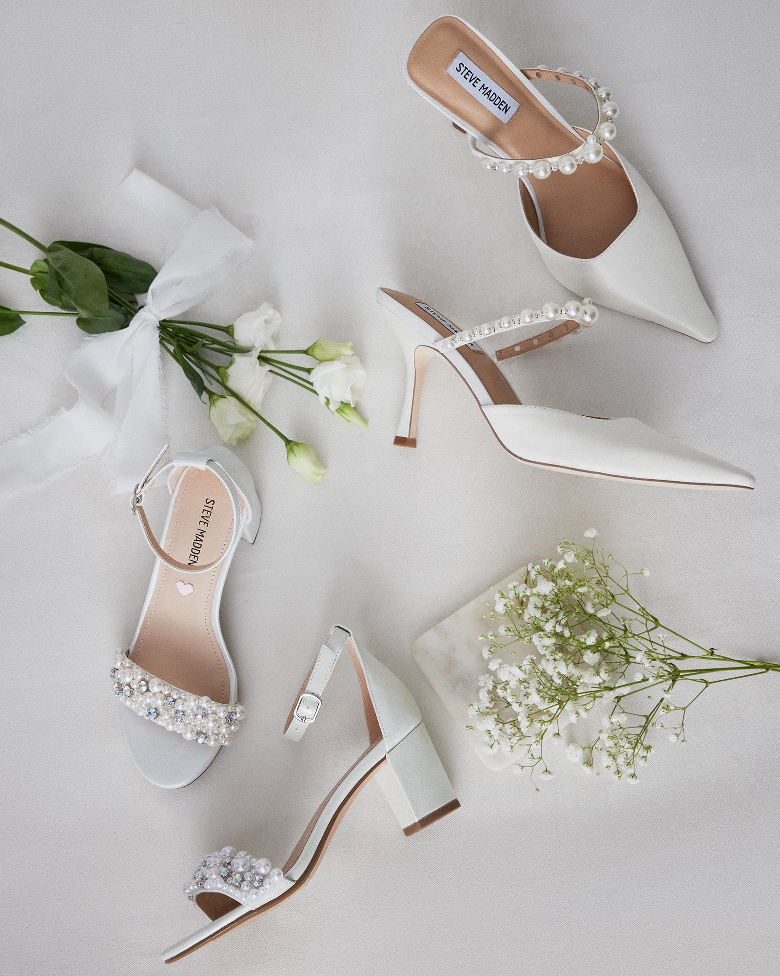 Closeup of white block heel sandals showing ankle buckle and vegan leather