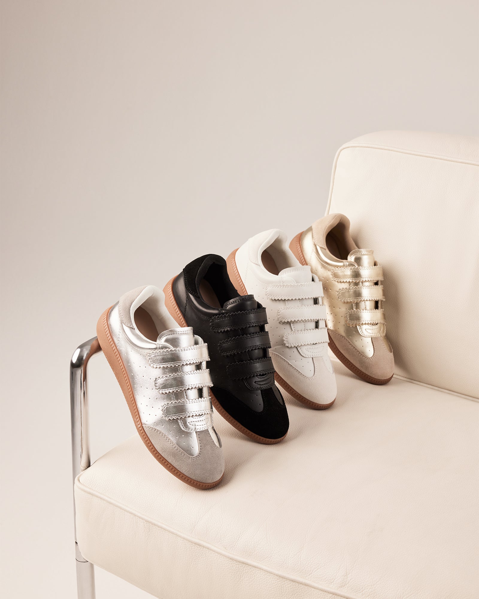 Side view of black leather sneakers with suede trim and velcro strap
