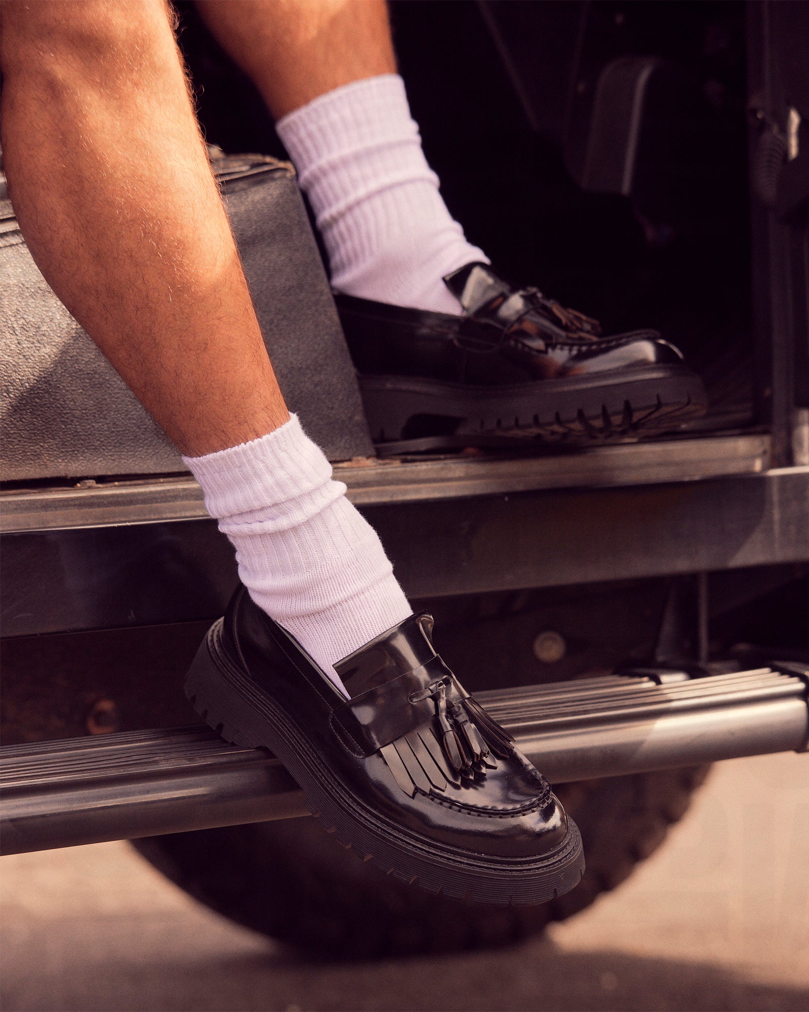 Men's black leather ZEV loafers with tassel detail, displayed on a neutral backdrop.