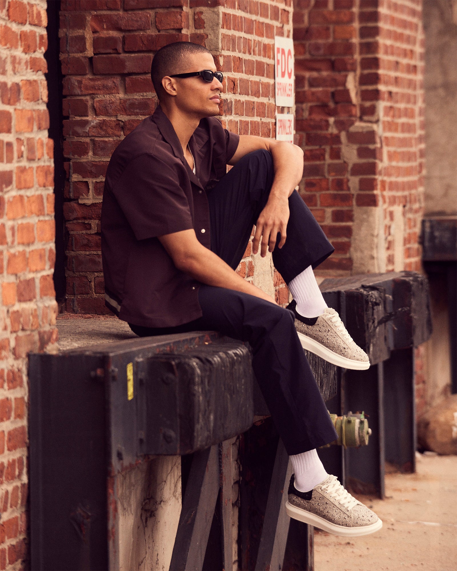 Close-up side view of men's white platform sneakers with rhinestones on NYC pavement