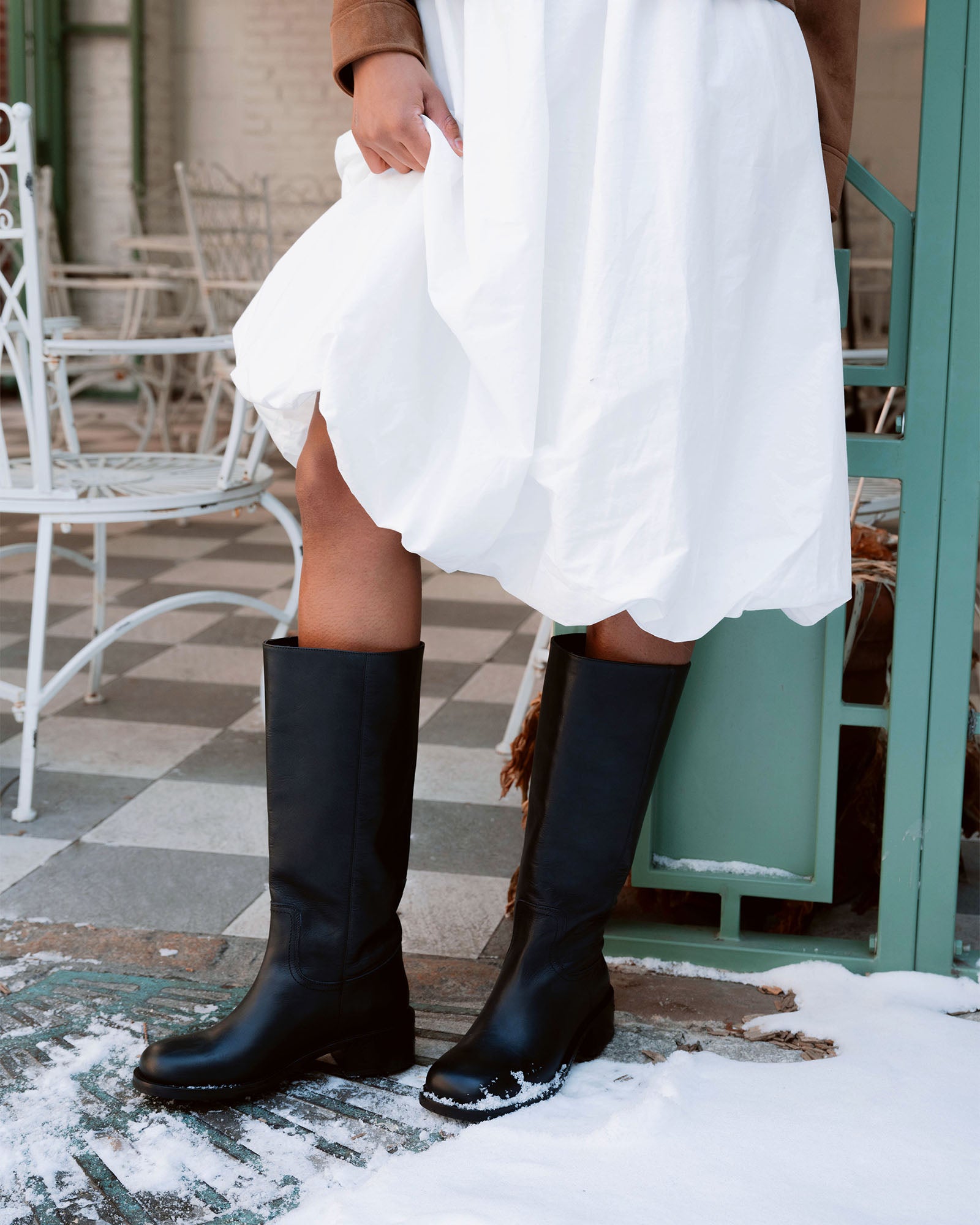 Side view of RIGGS black leather knee-high boots highlighting the sleek design