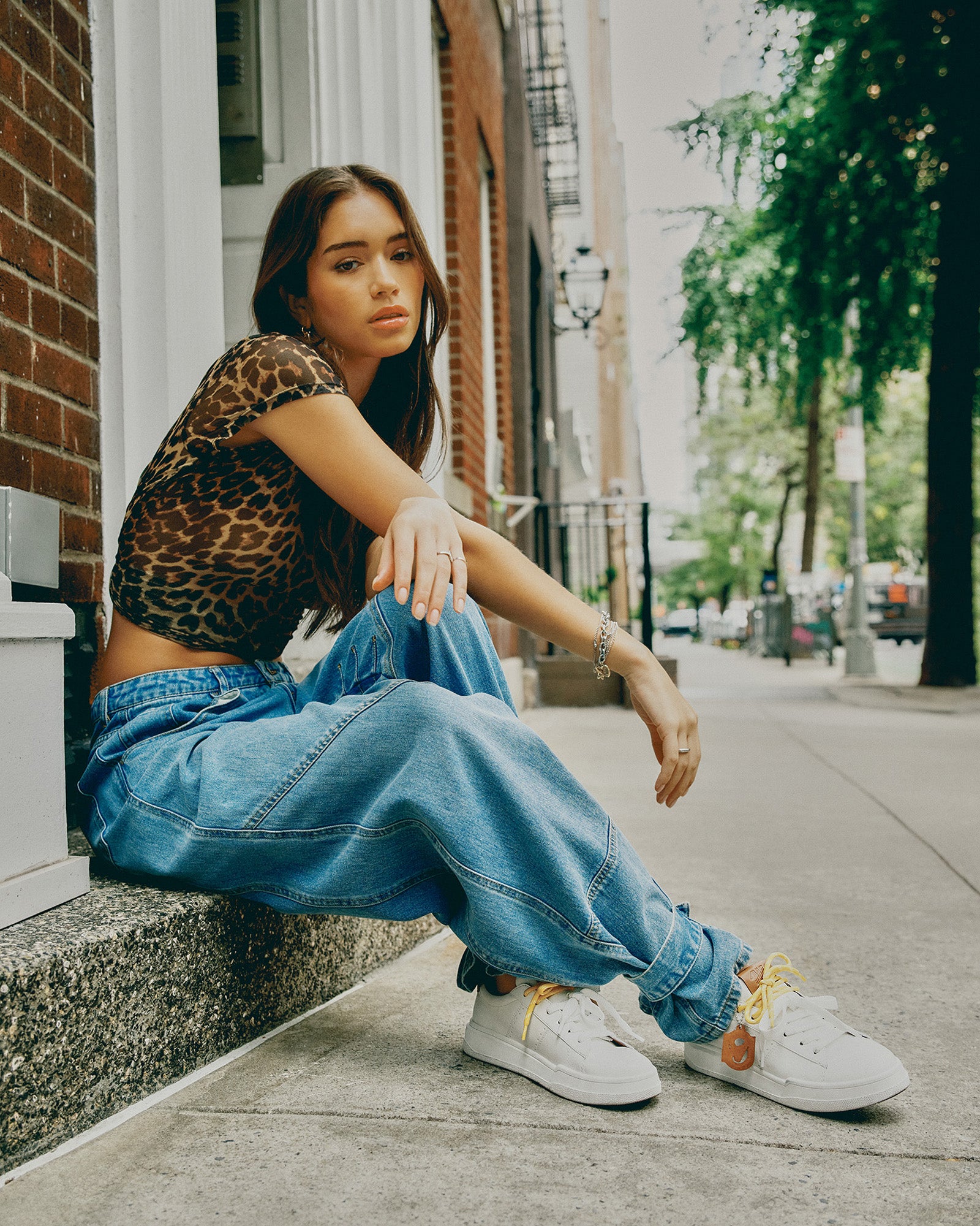 Side profile of white and tan lace up sneakers with decorative charm—ideal for city walks.