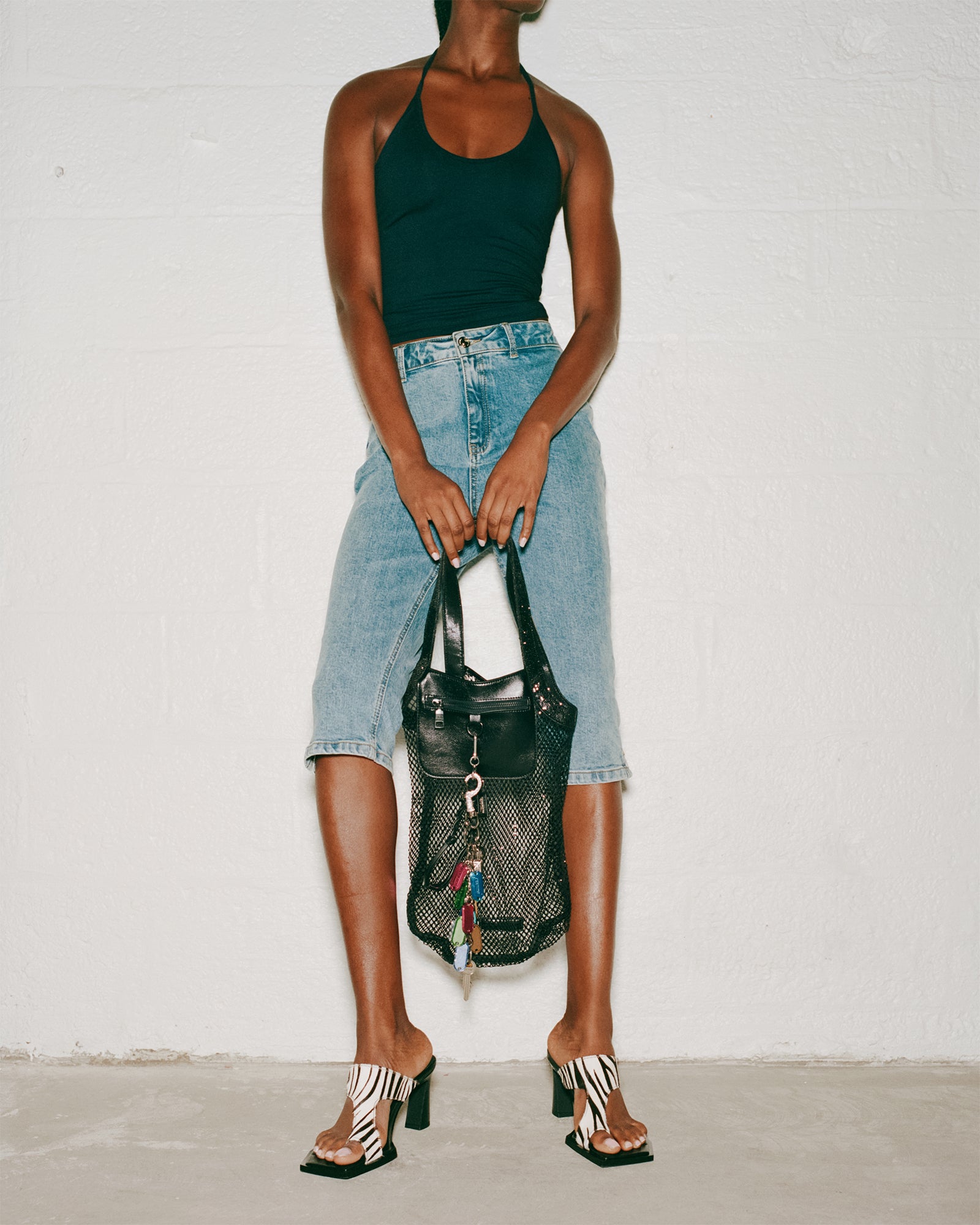 Stylish black coach shoulder bag displayed on a table with accessories.