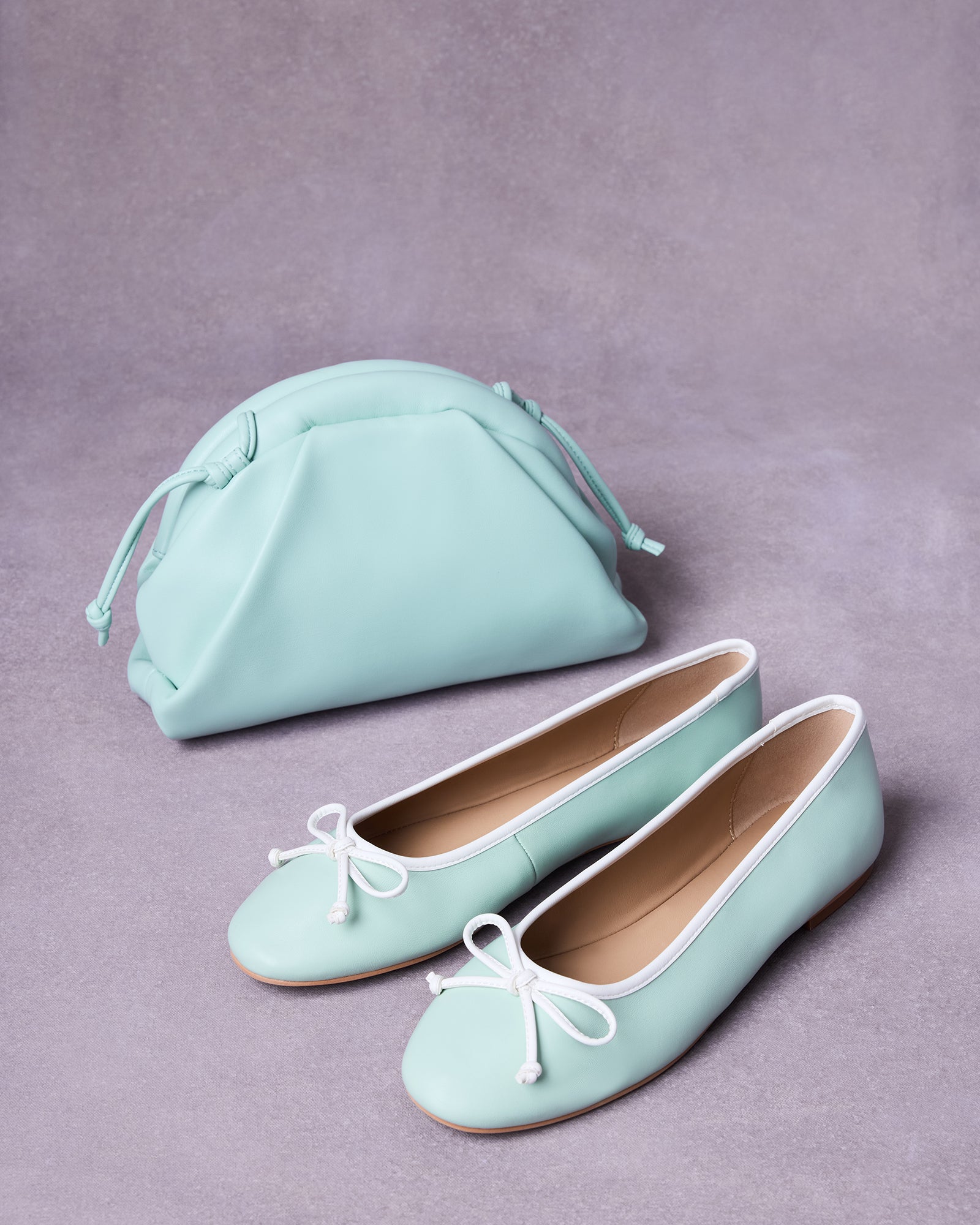 Overhead shot of ballet flats ballerina with pistachio crossbody bag on a white linen surface