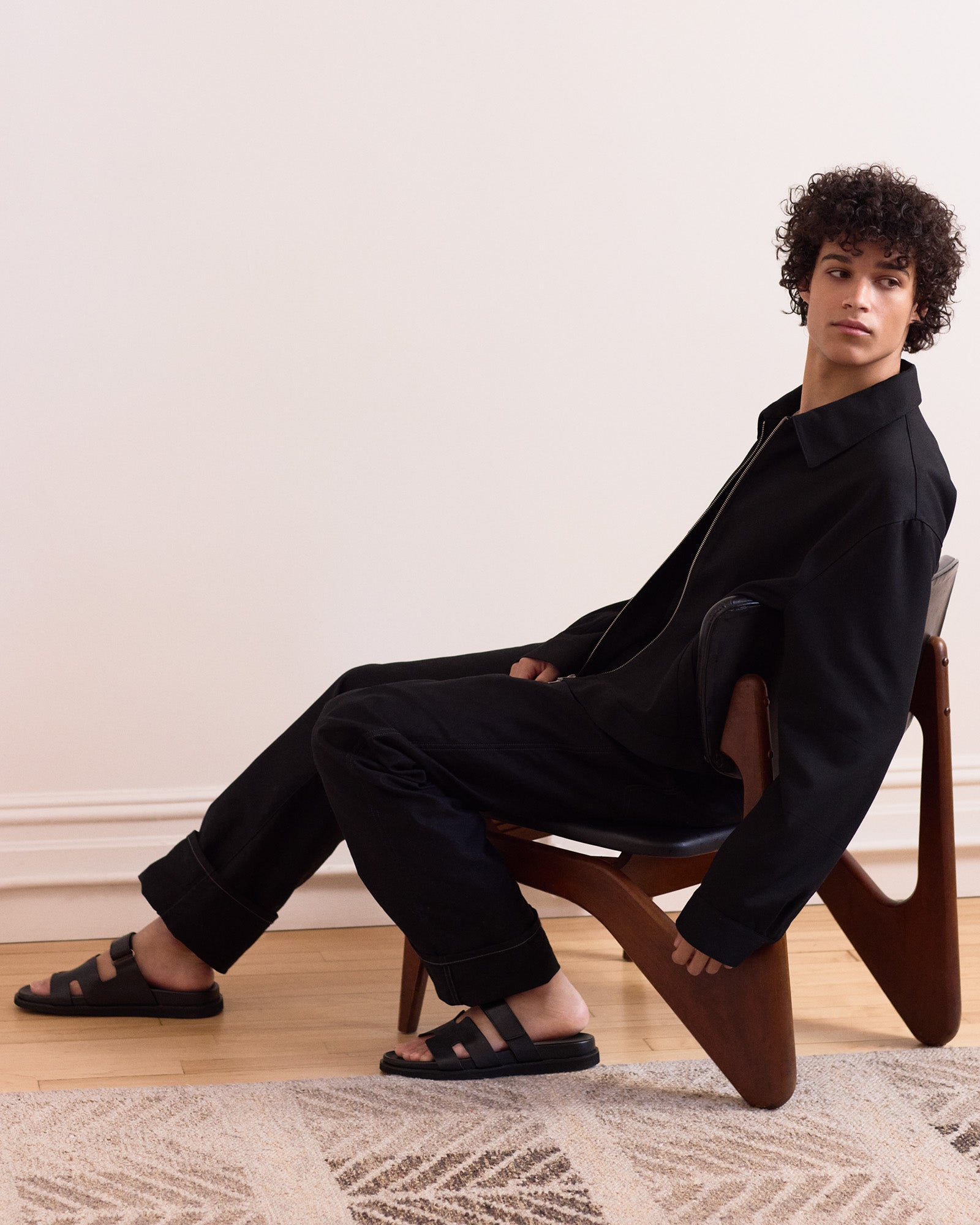 Side view of mens black leather sandals on a sunny outdoor setting