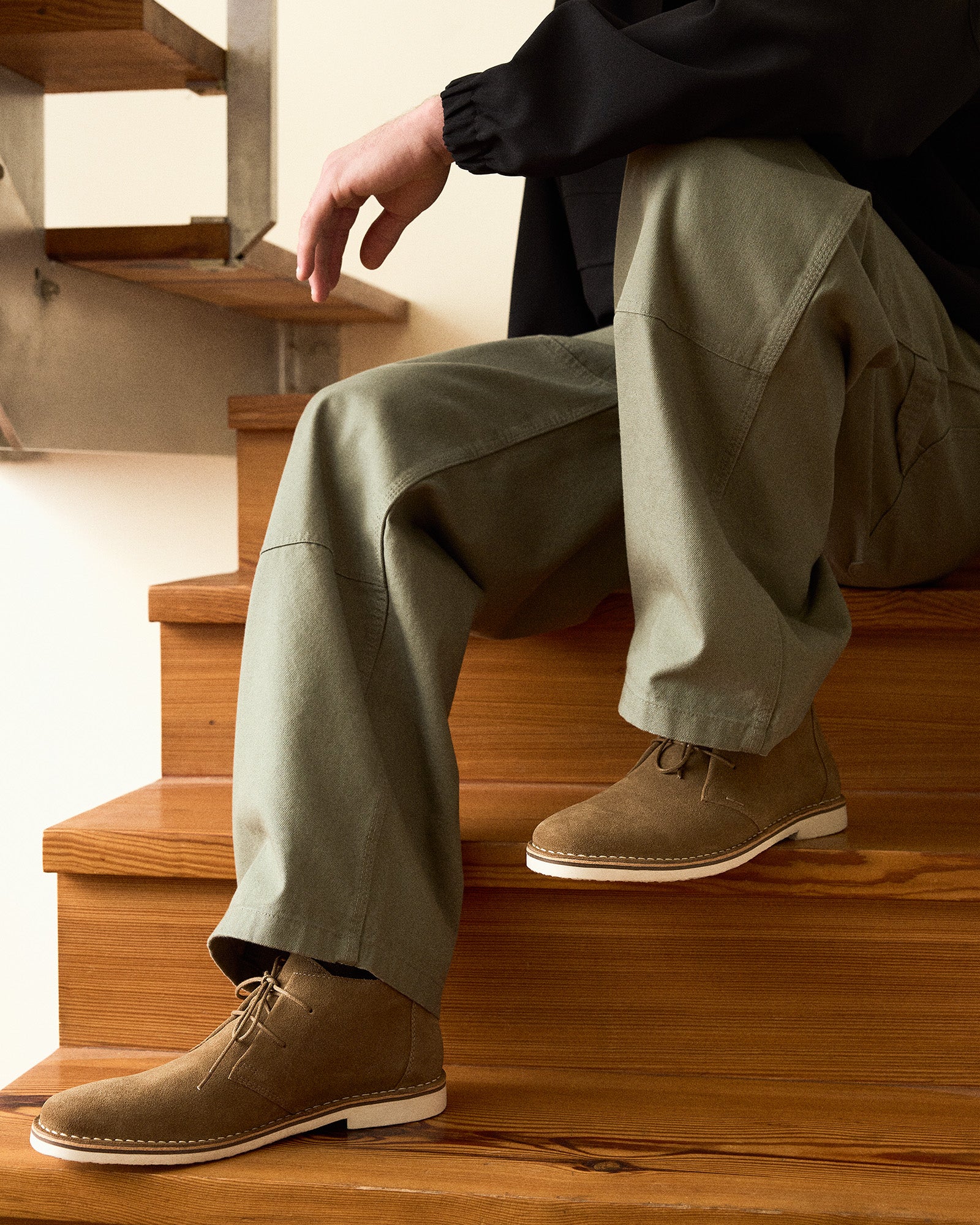 Side view of HERO cognac suede ankle boots on a wooden floor.