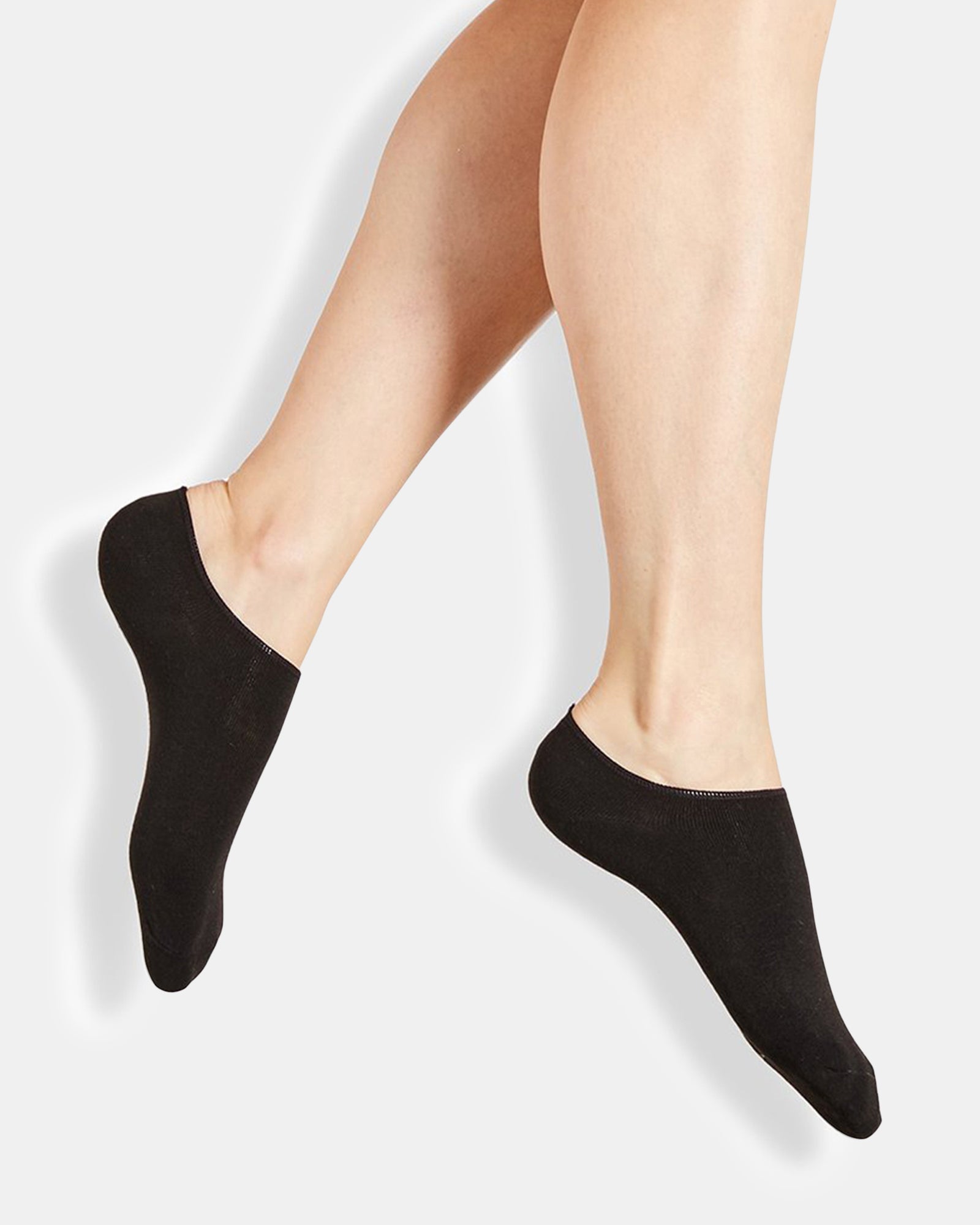 Close-up of black footies paired with white sneakers during a city walk