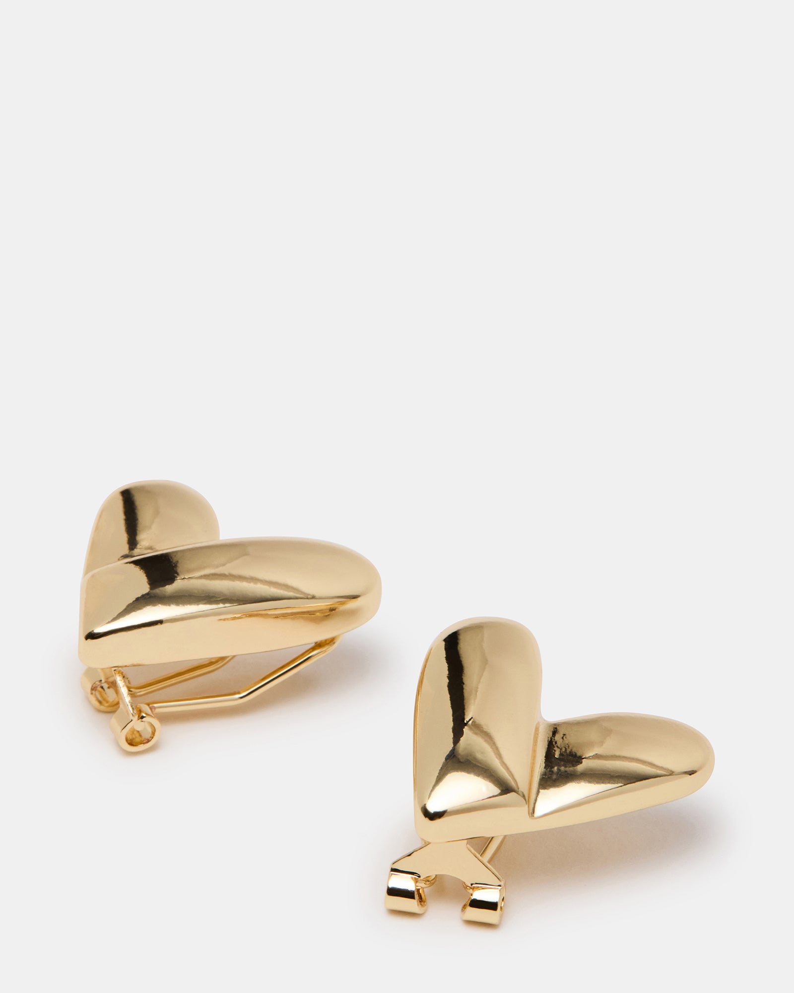 Gold heart earrings worn by a woman, showcasing everyday elegance