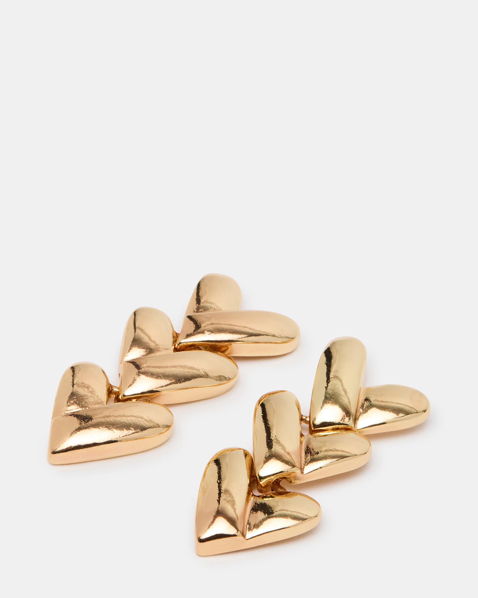 Gold heart stud earrings worn with a casual denim jacket for everyday style