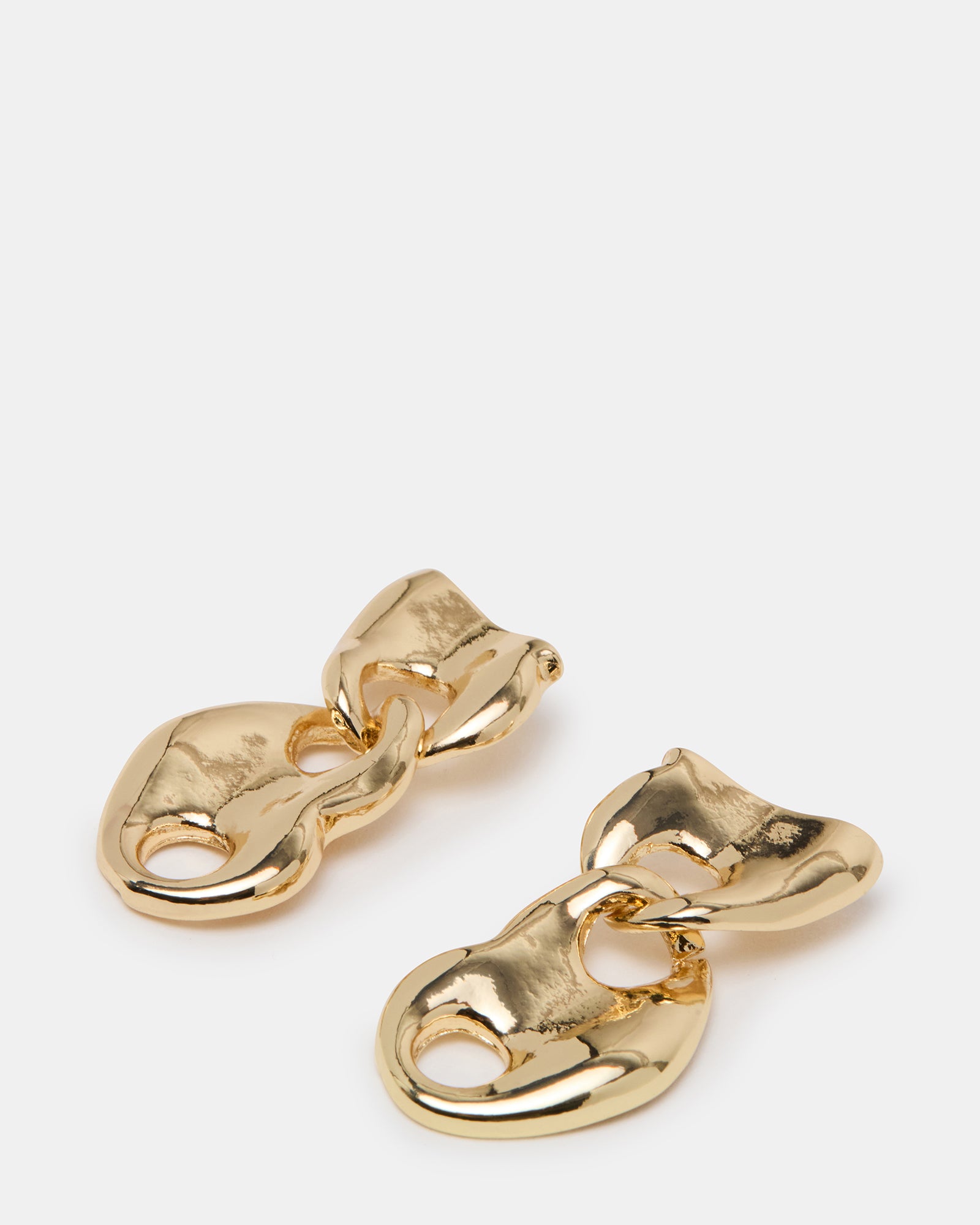 Model wearing gold drop earrings at a casual outdoor event, highlighting their versatile style.
