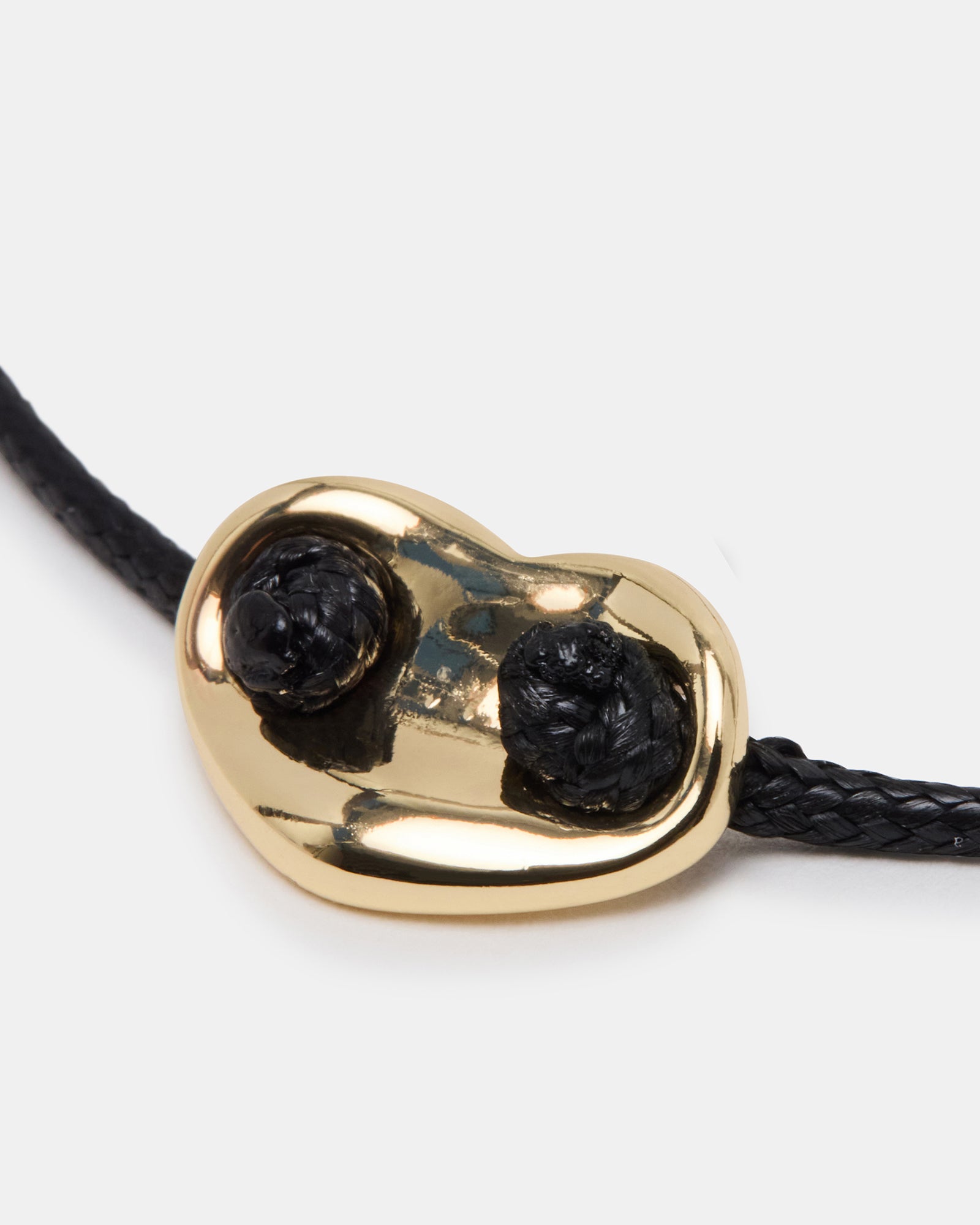 Elegant black bolo bracelet displayed on a wooden surface.