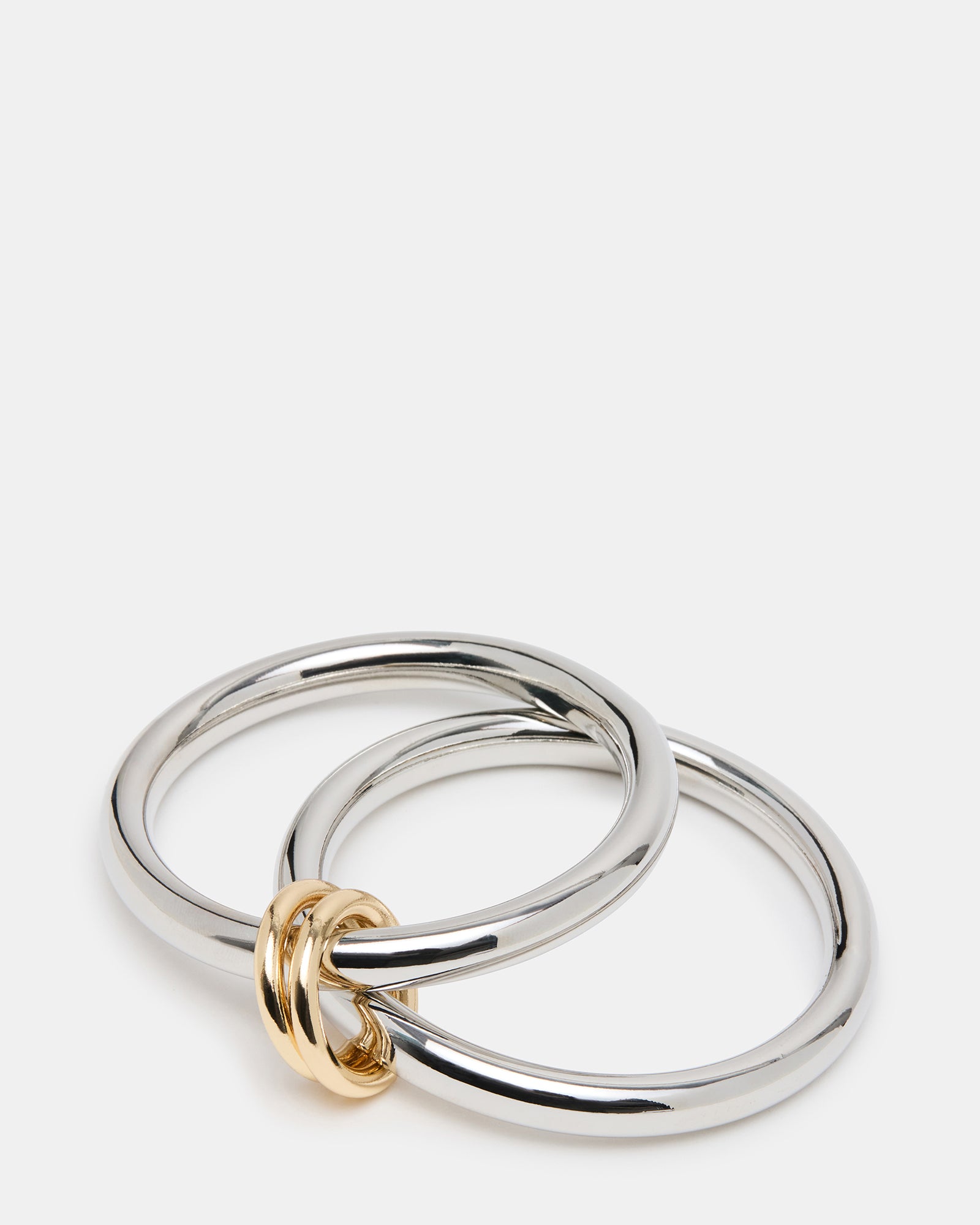 Stylish two-tone bangle bracelets worn together for a chic look.