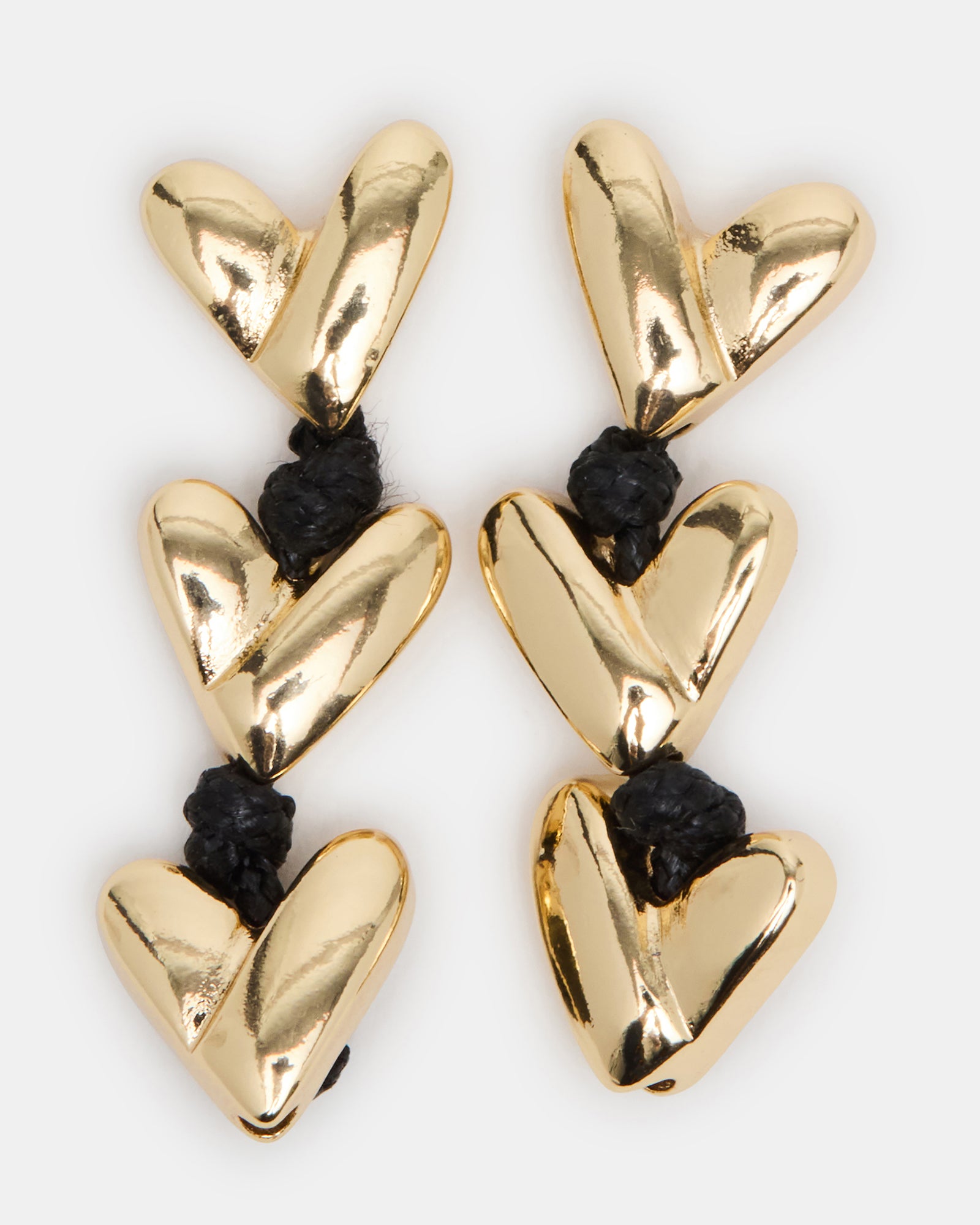 Front view of black and gold heart earrings with sleek linear design and black cord details