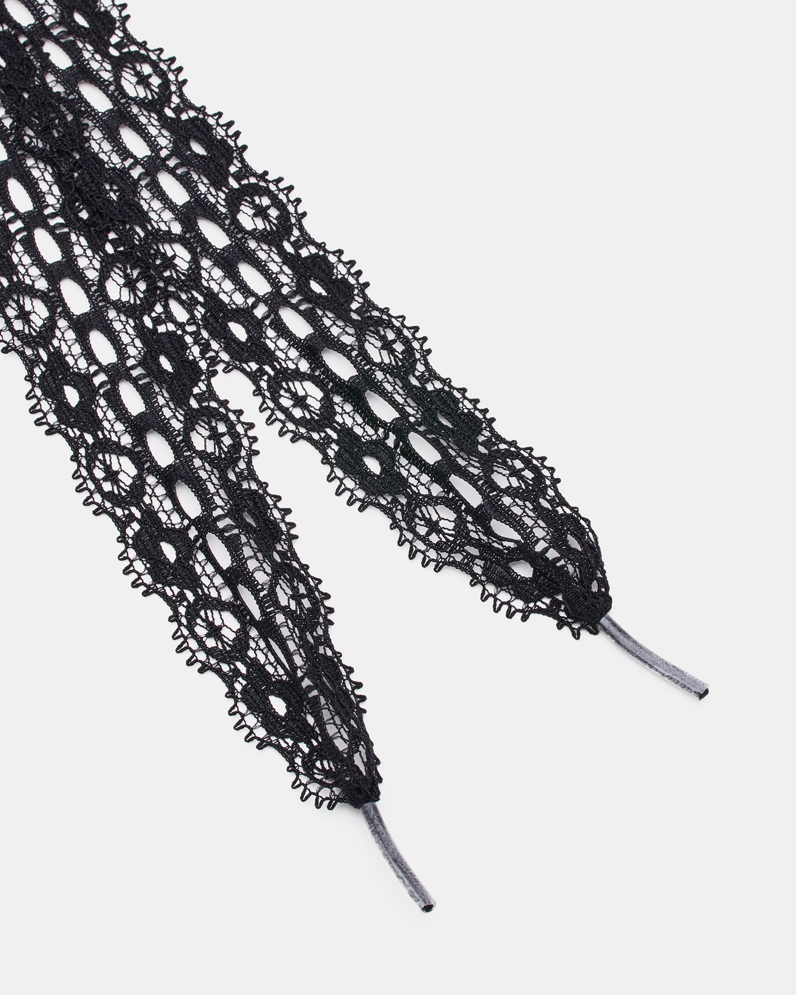 Close-up of black shoe laces adorned with decorative charms.
