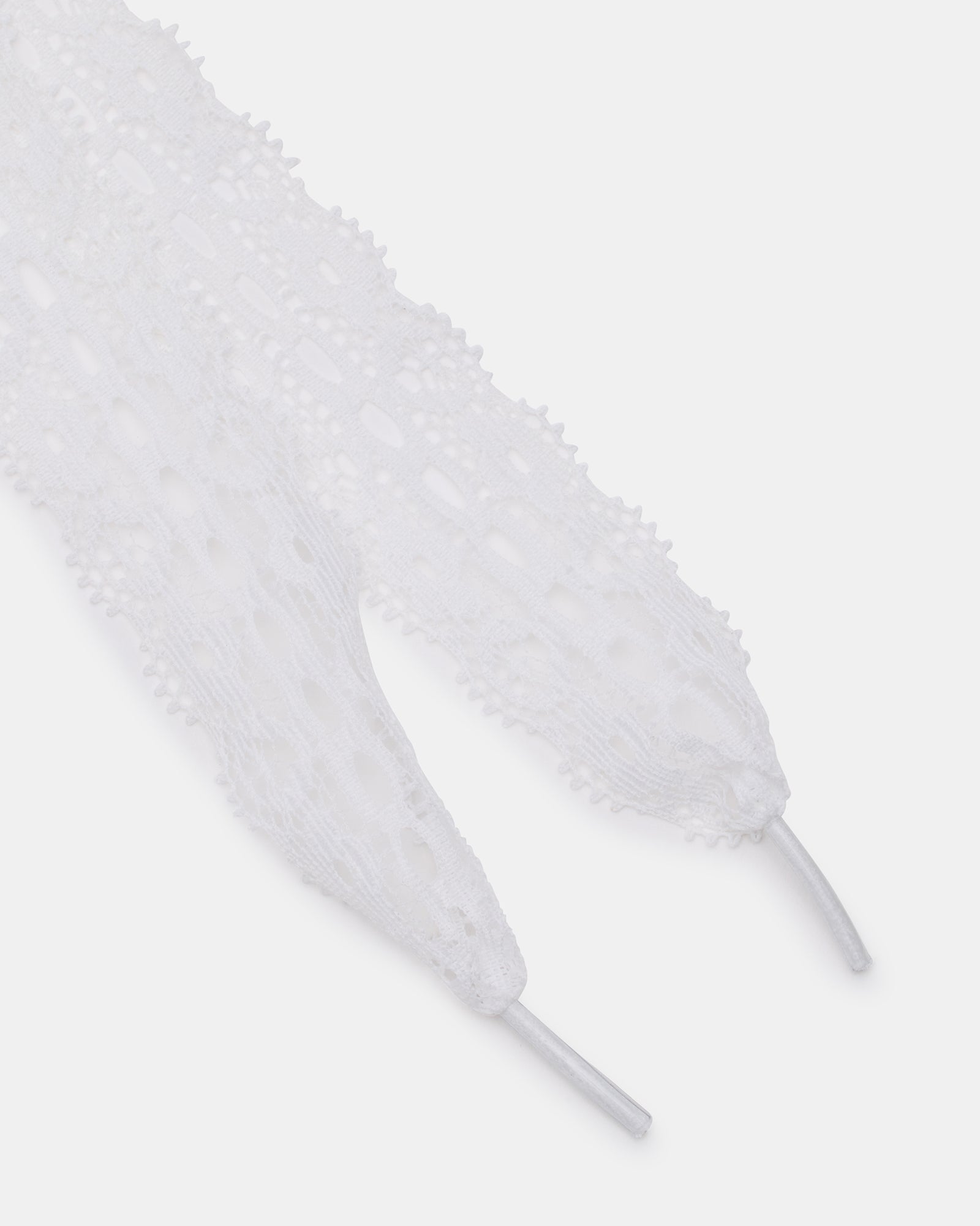 Close-up of charming white shoelaces with heart and flower charms.