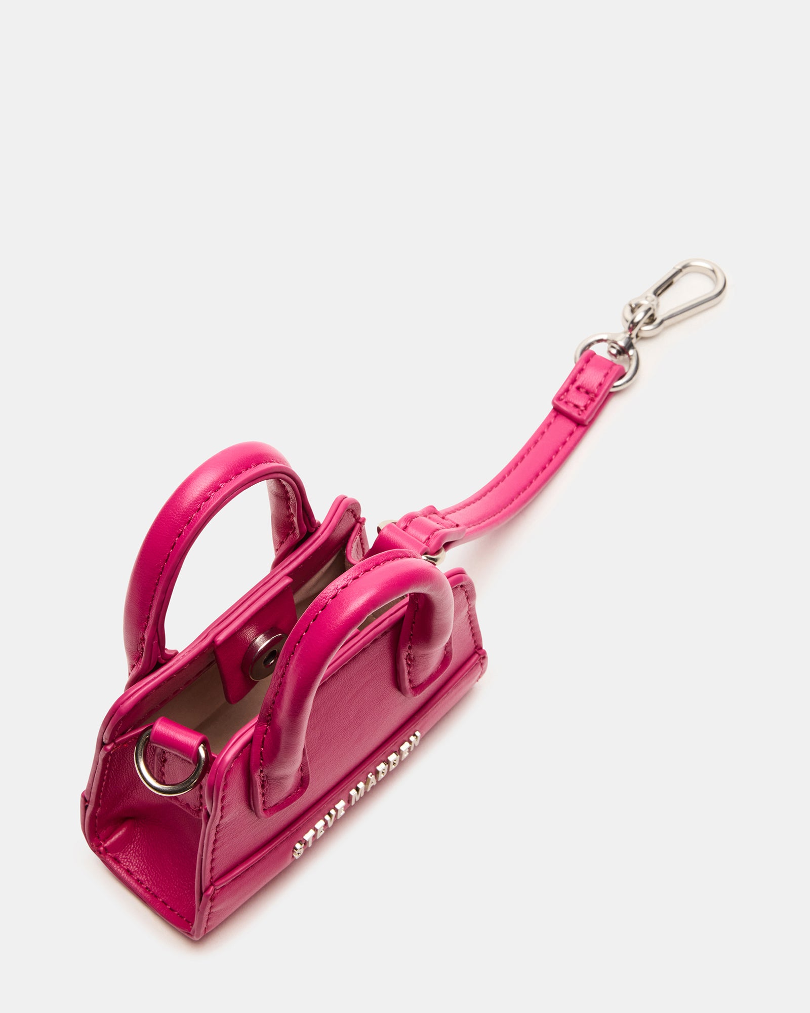 Close-up of fuchsia mini tote bag charm attached to a handbag.