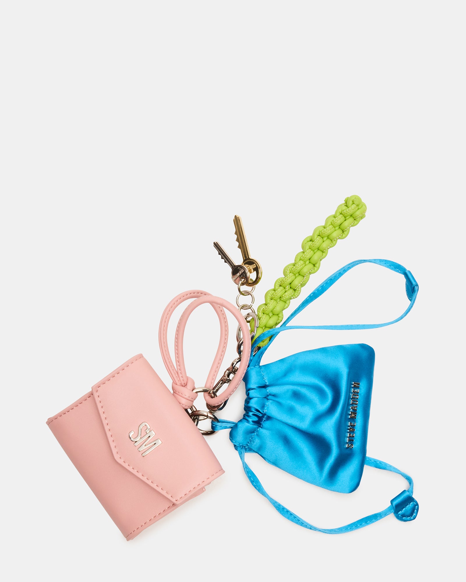 Colorful travel bag charm in coral multi attached to a suitcase