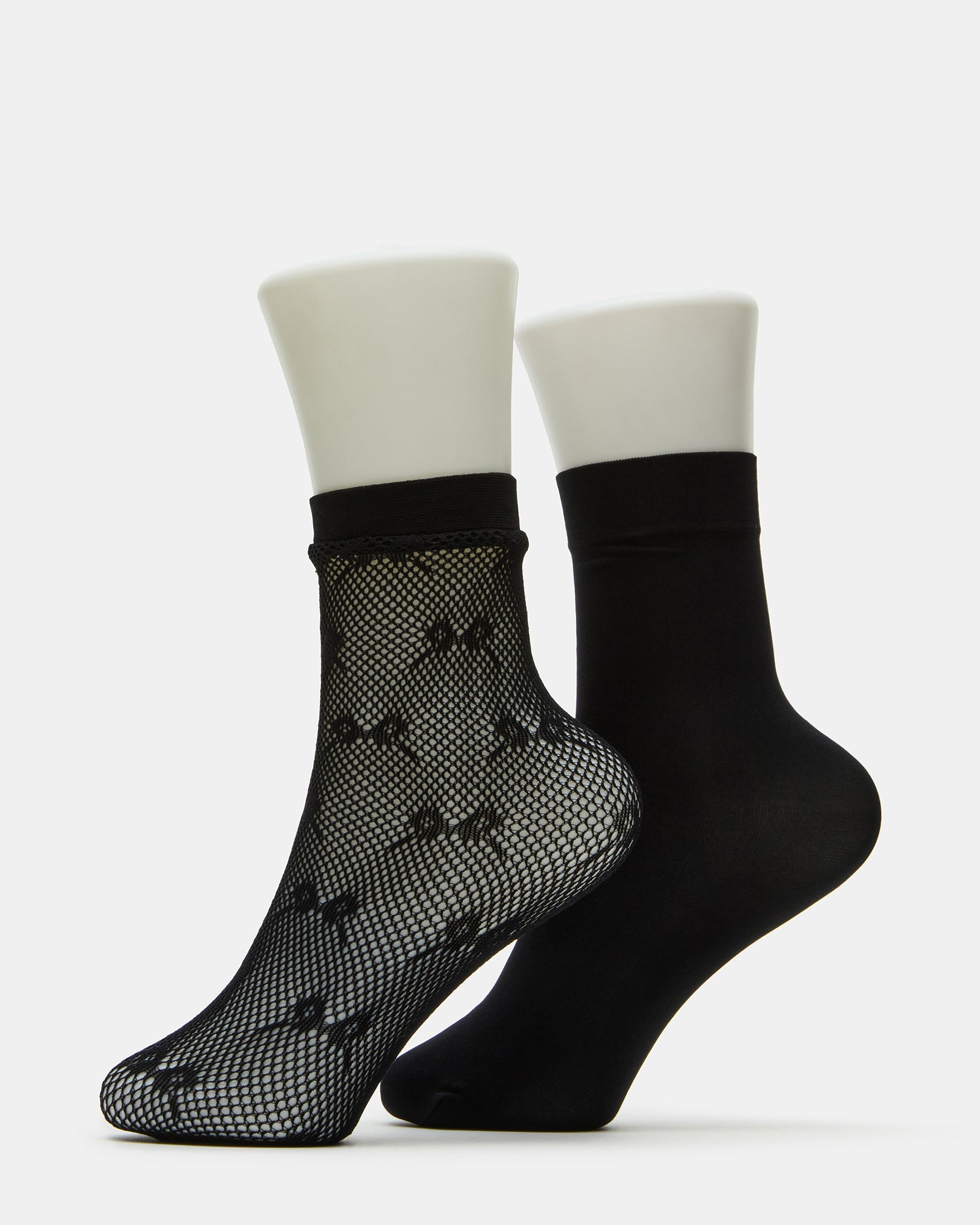 Black fishnet socks draped over ballet flats showing lace detail