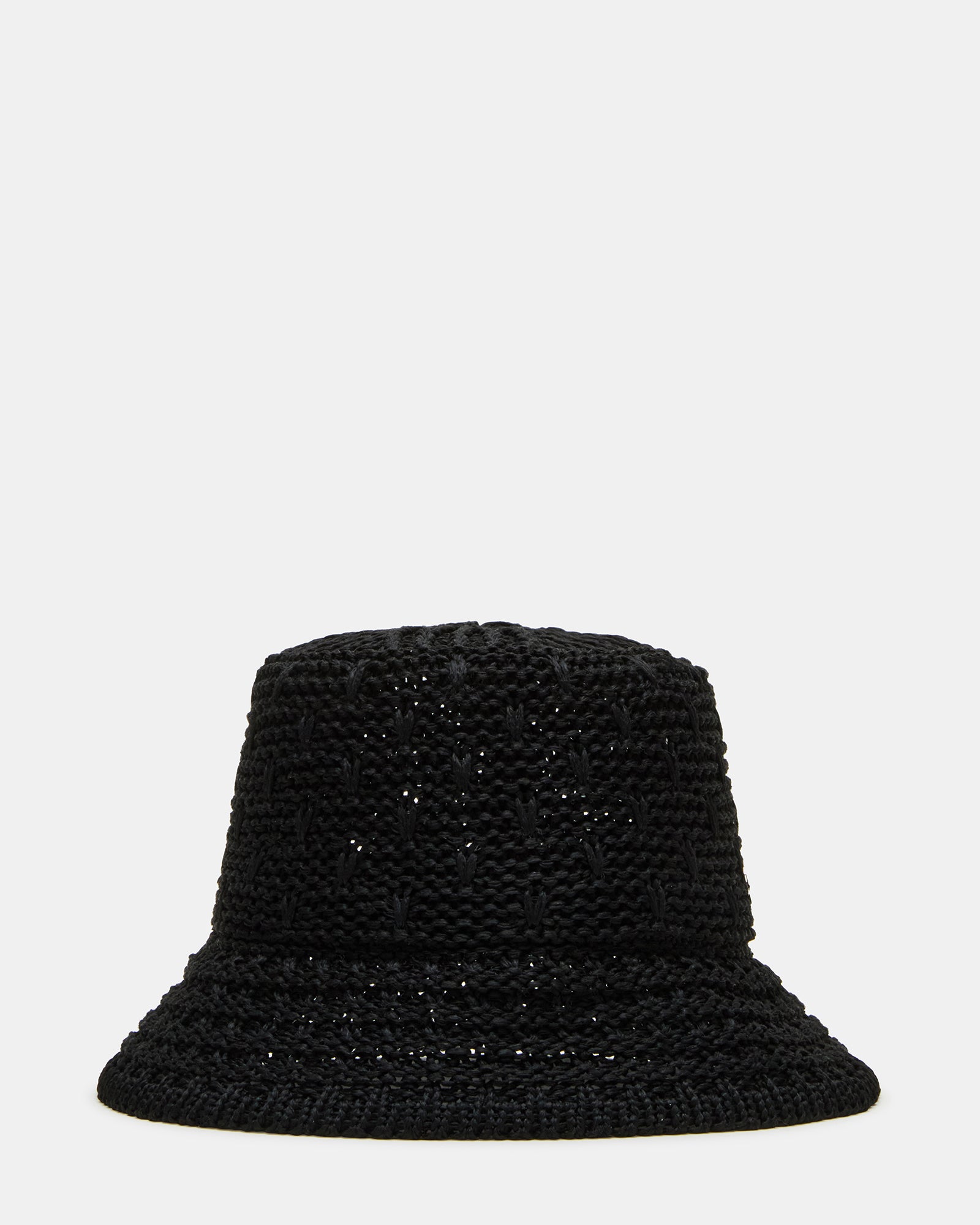 Black straw bucket hat on a sandy beach with ocean backdrop