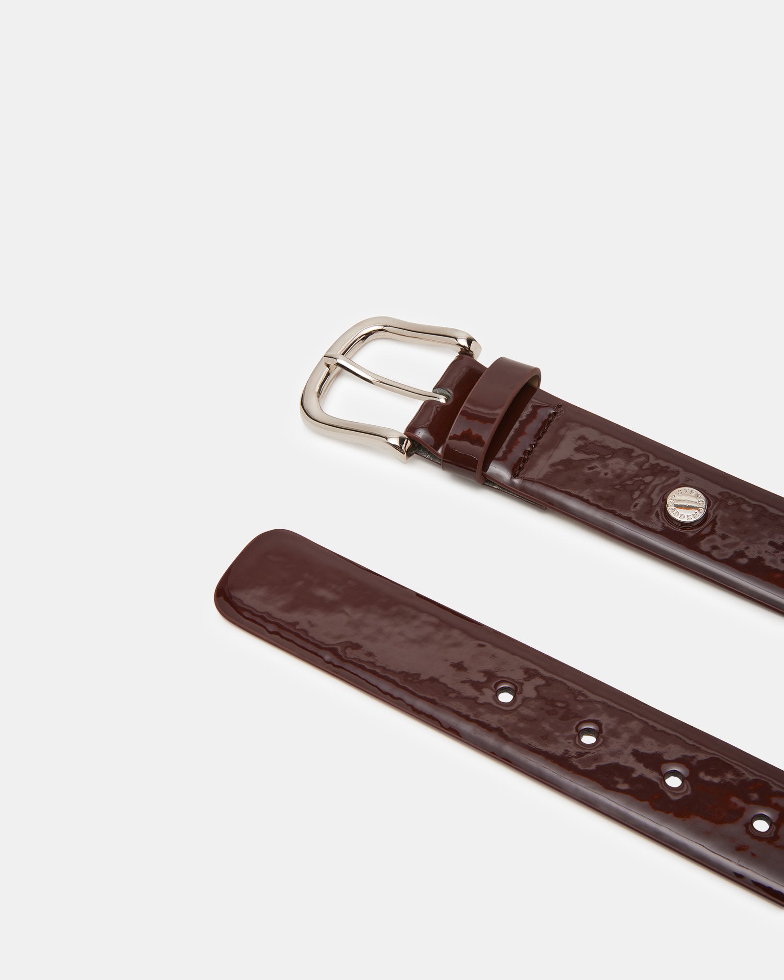 Elegant wine patent belt styled with a formal outfit for a polished look.