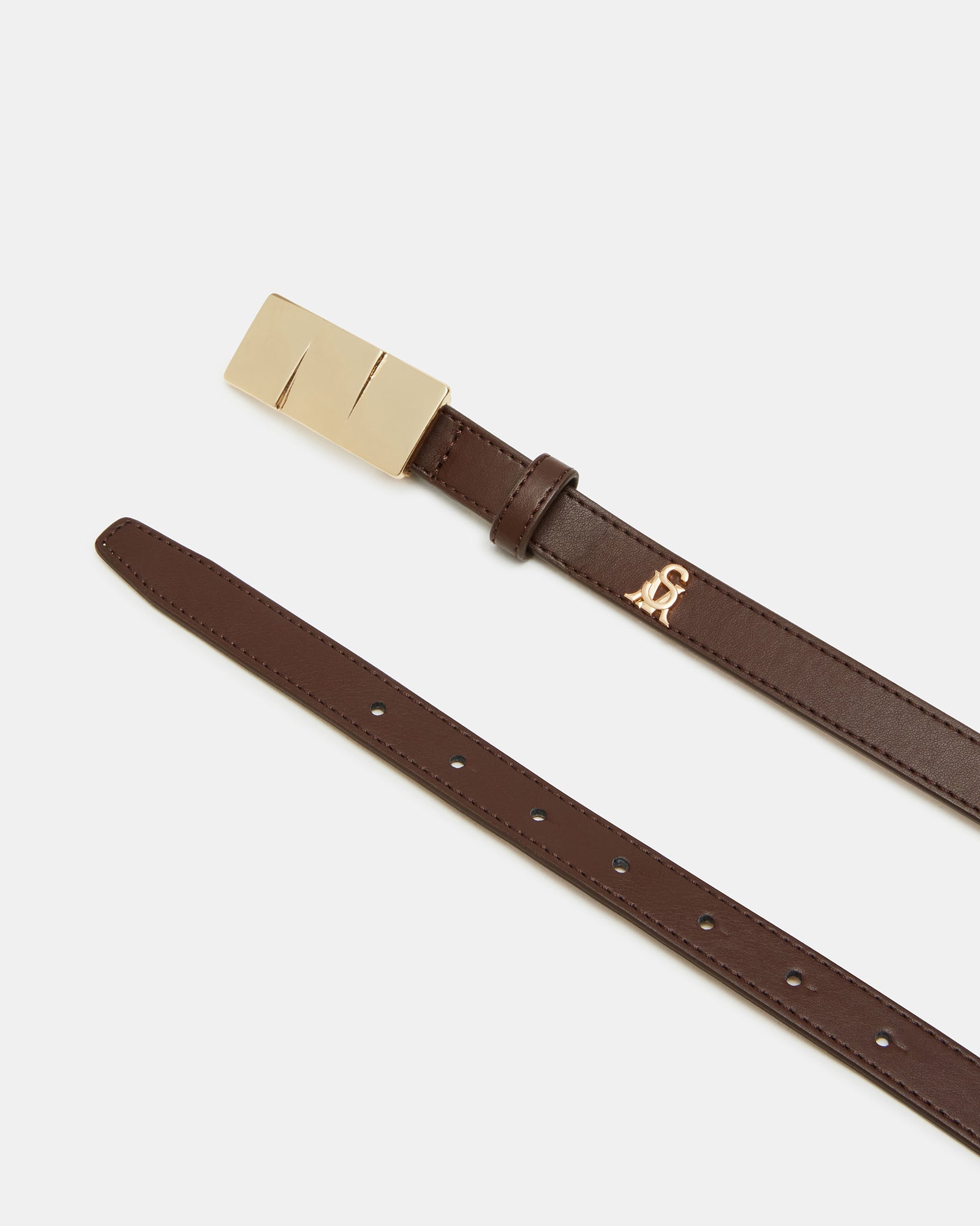 Close-up of square gold hardware stacked buckle against chocolate leather