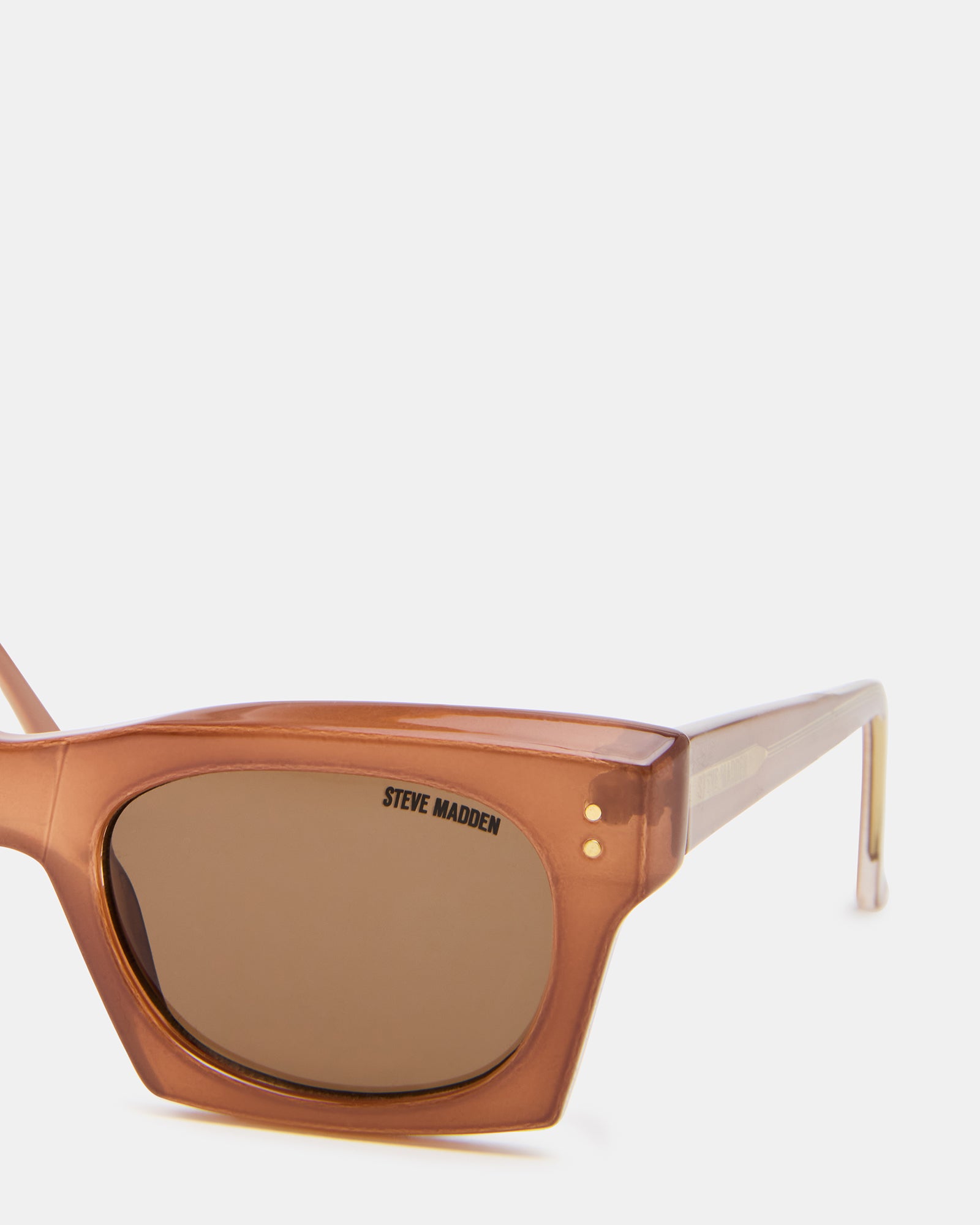 Model wearing brown sunglasses outdoors, showcasing UV protection.