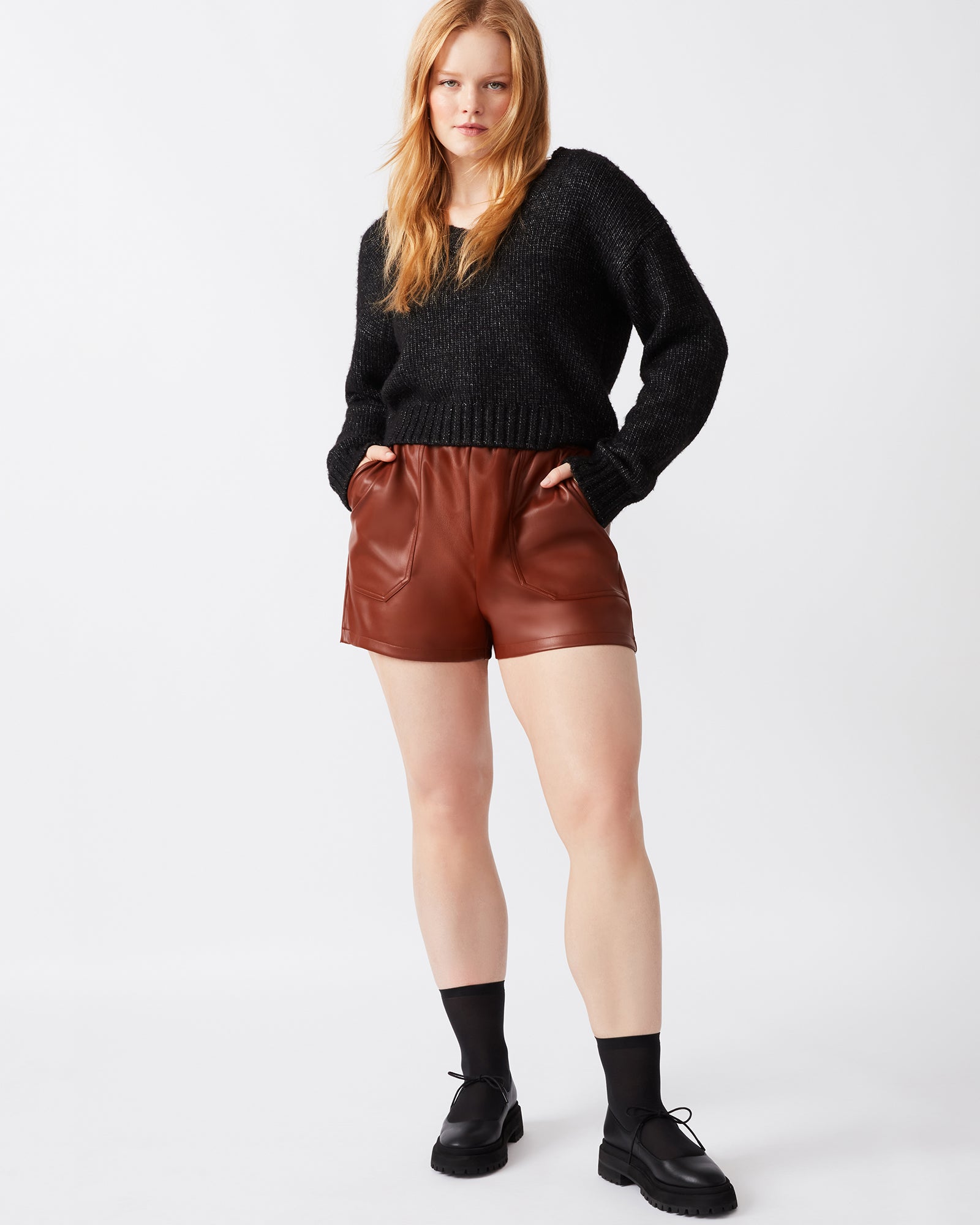 Close-up of women's faux leather shorts with elastic waistband and side pockets