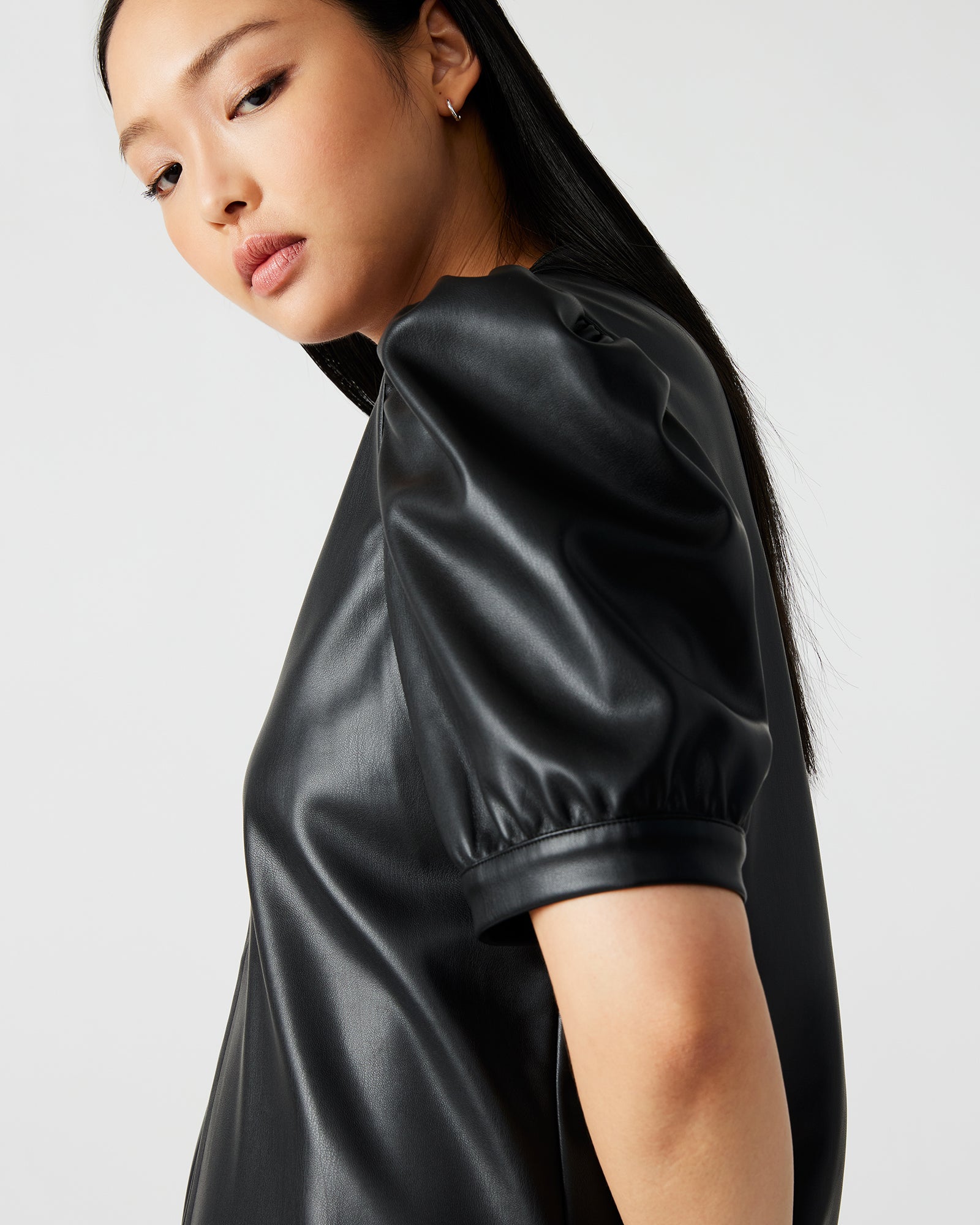 Close-up of faux leather texture and split V-neck detail