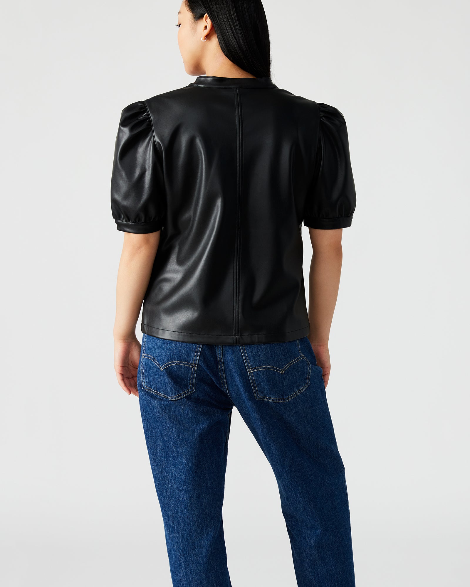 Front view of black puff sleeve crop top styled with high-waisted jeans