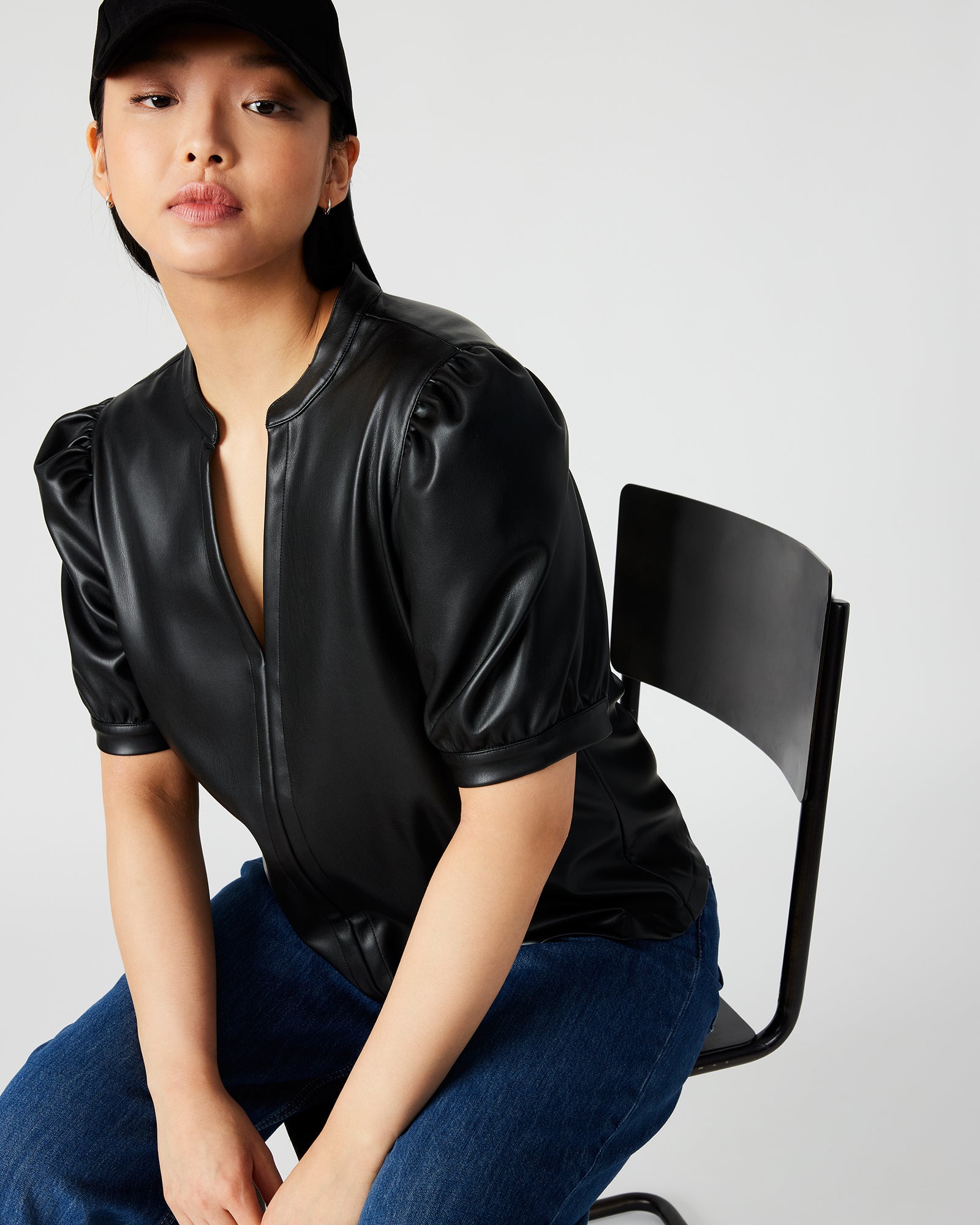 Close-up of faux leather texture and split V-neck detail