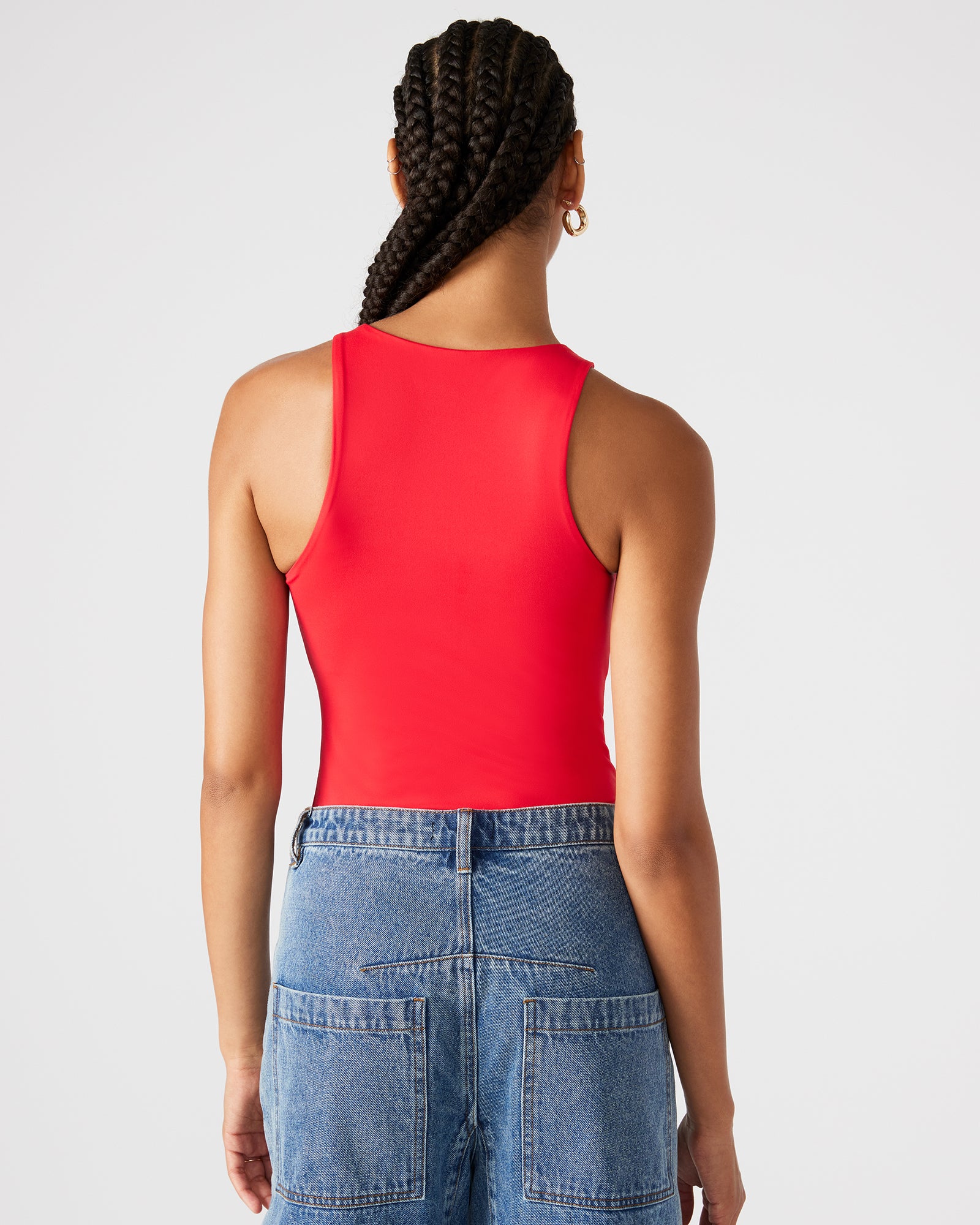 Side view of red bodysuit styled with high-waisted trousers for city chic look