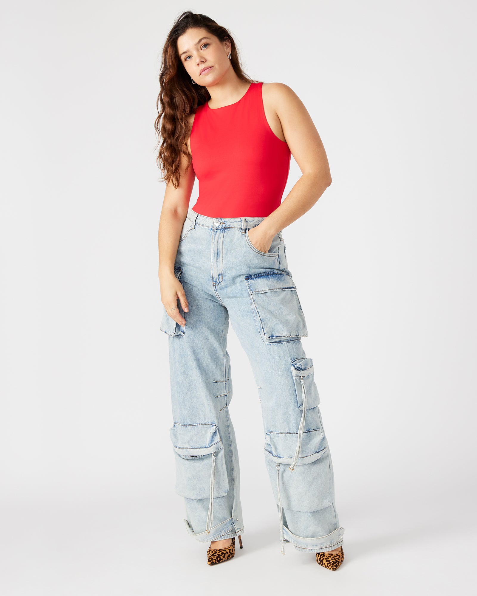 Side view of red bodysuit styled with high-waisted trousers for city chic look