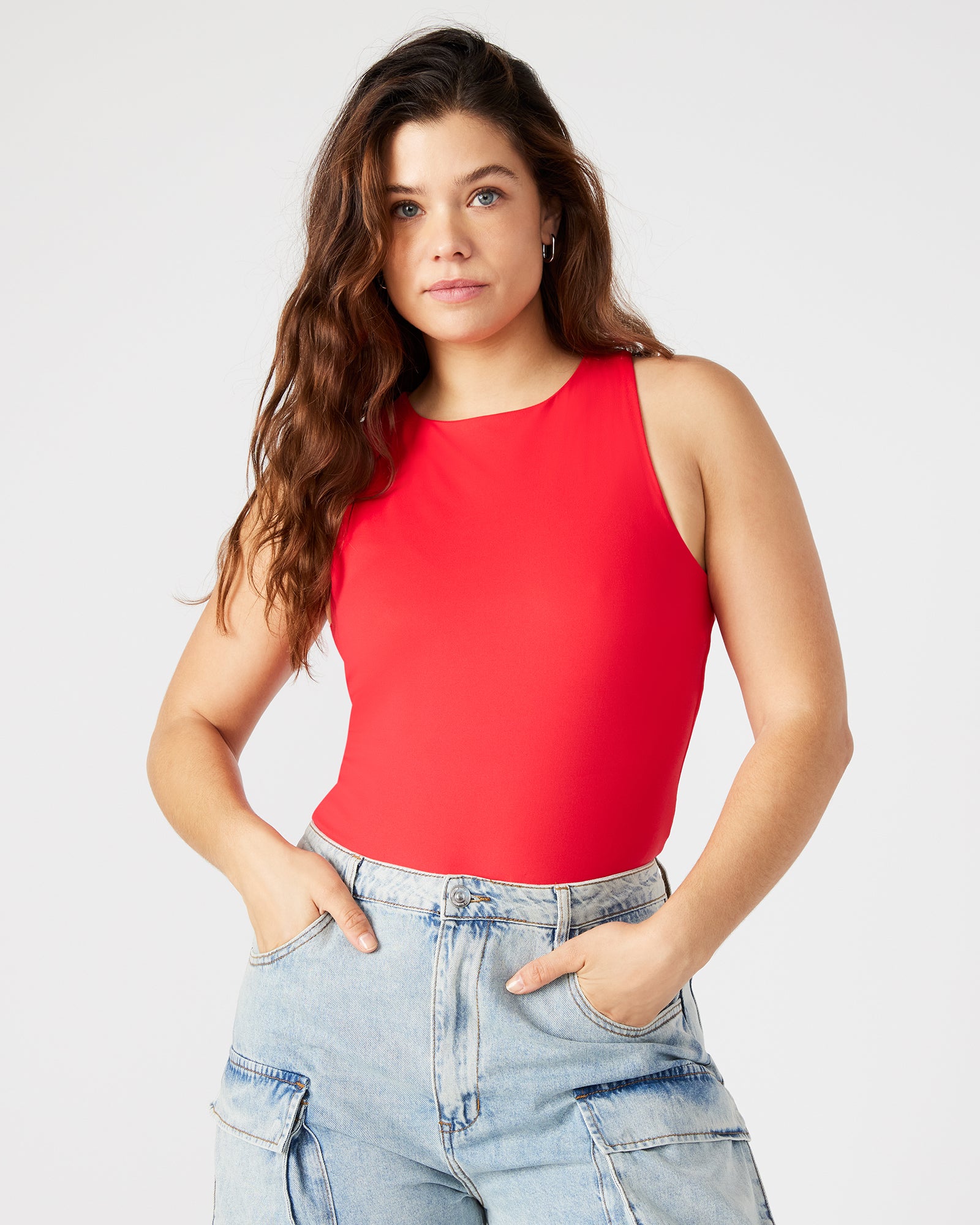 Side view of red bodysuit styled with high-waisted trousers for city chic look