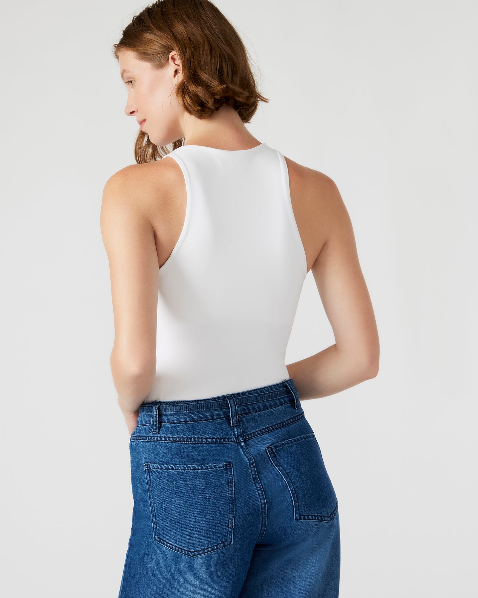 Close-up of white lace bodysuit neckline showing detailed texture