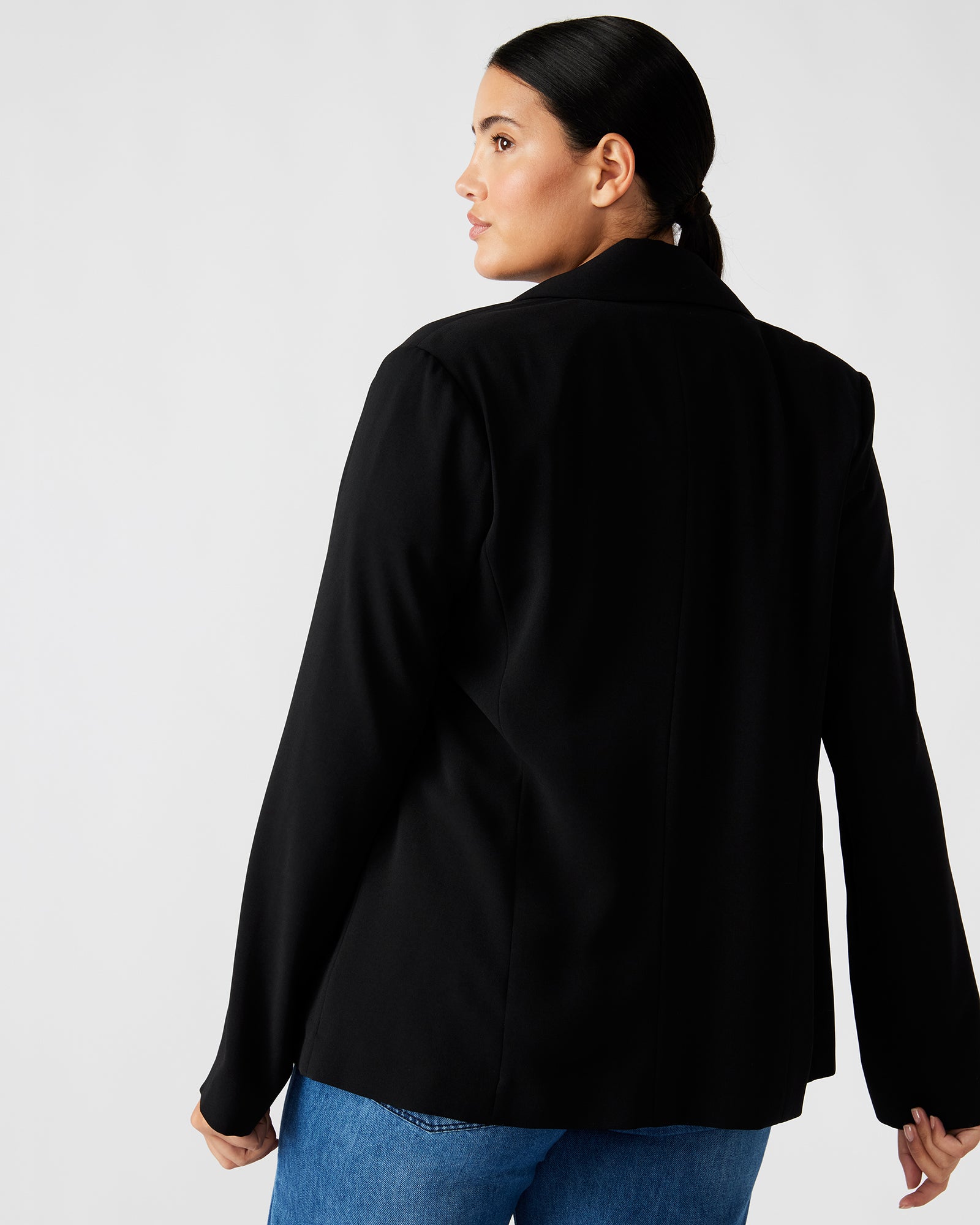 Back view highlighting the sleek lines of the black tailored blazer.