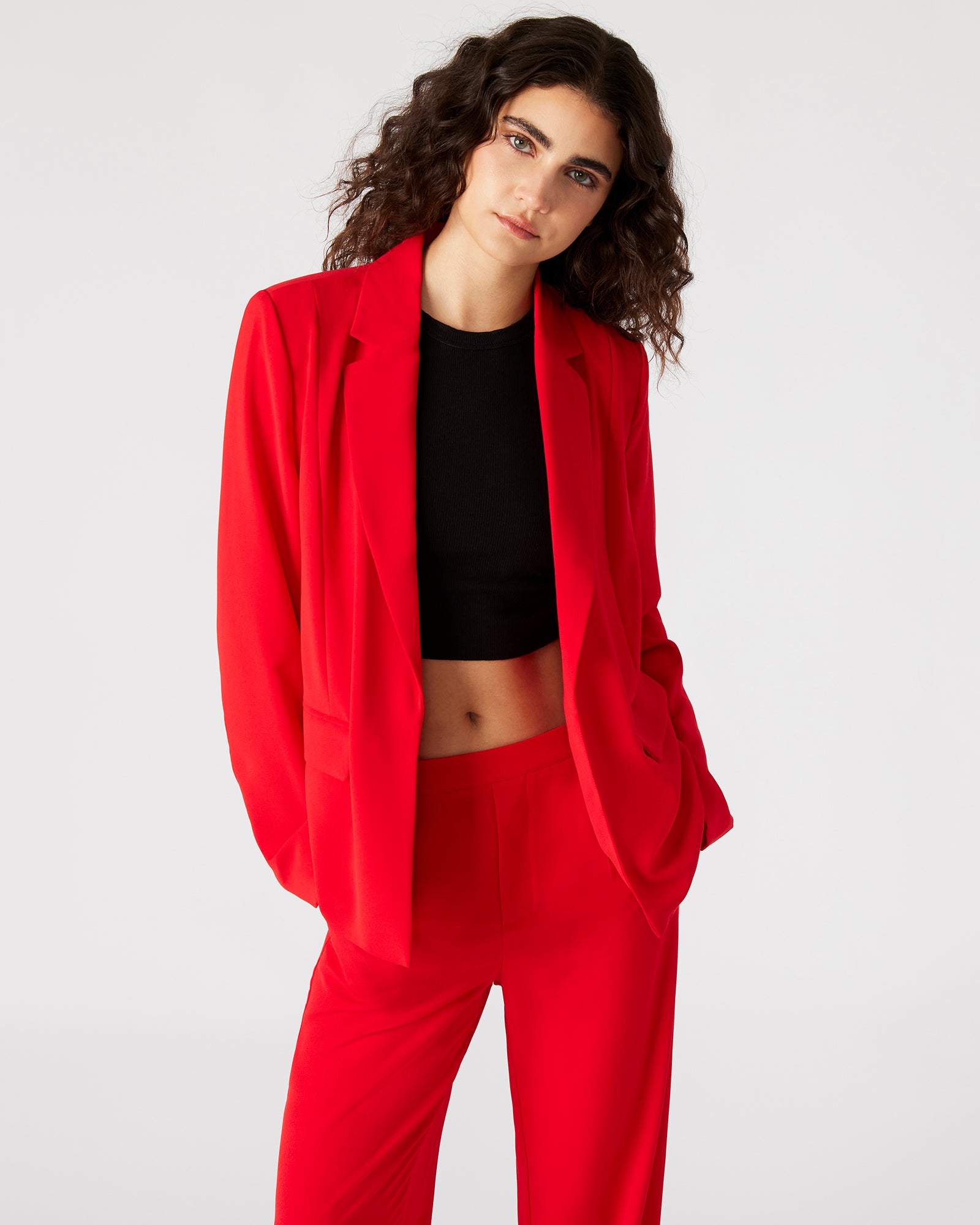 Detail shot of notched lapel and open cuffs on womens blazer, styled with minimal accessories.