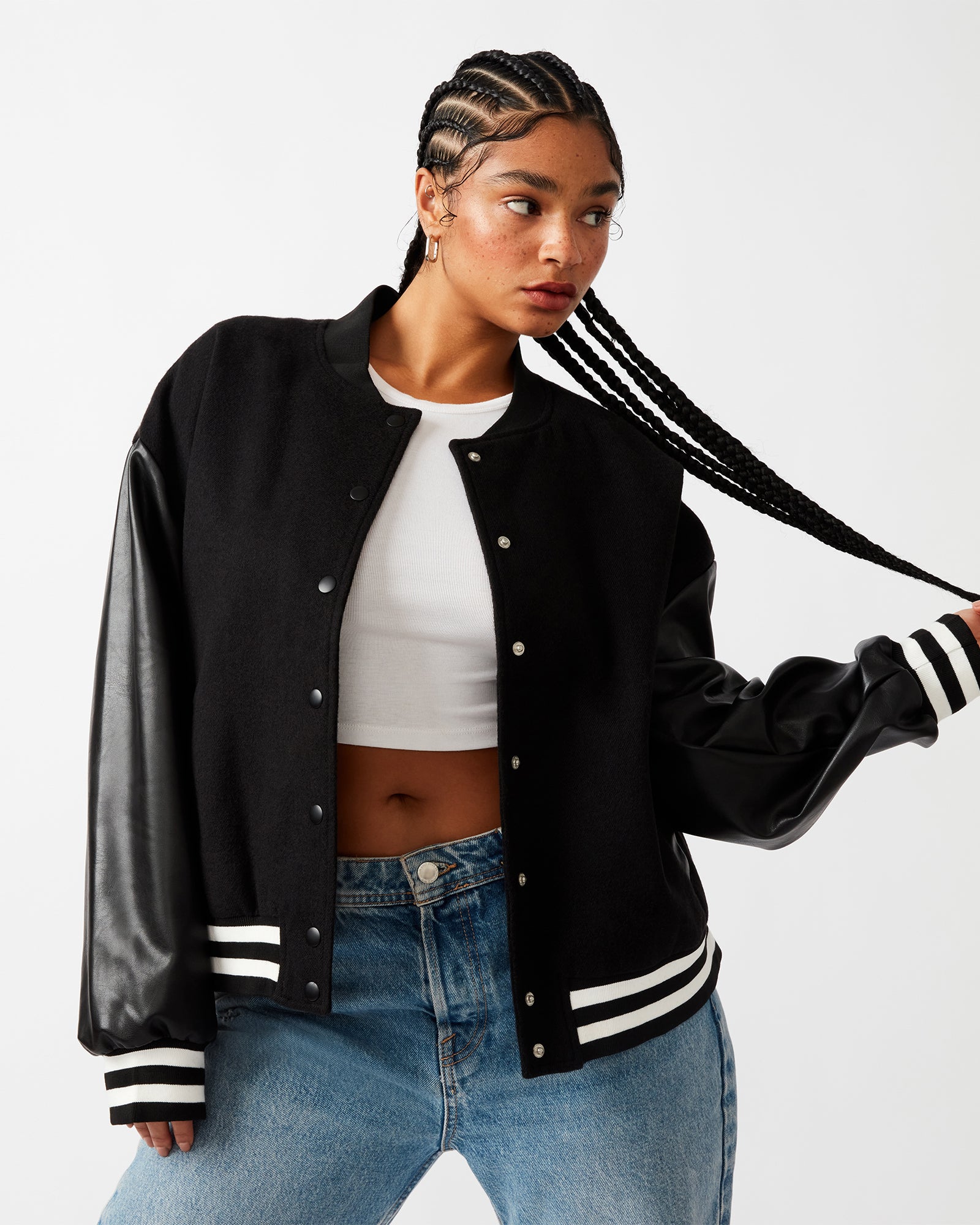 Front view of Alexandra black varsity jacket with striped trim and snap buttons