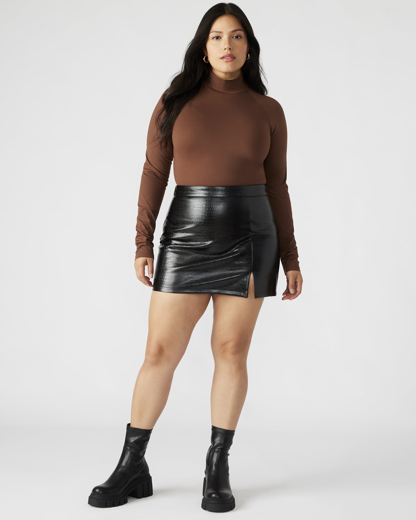 Close-up of the crocodile print texture and side slit detail on the mini skirt.