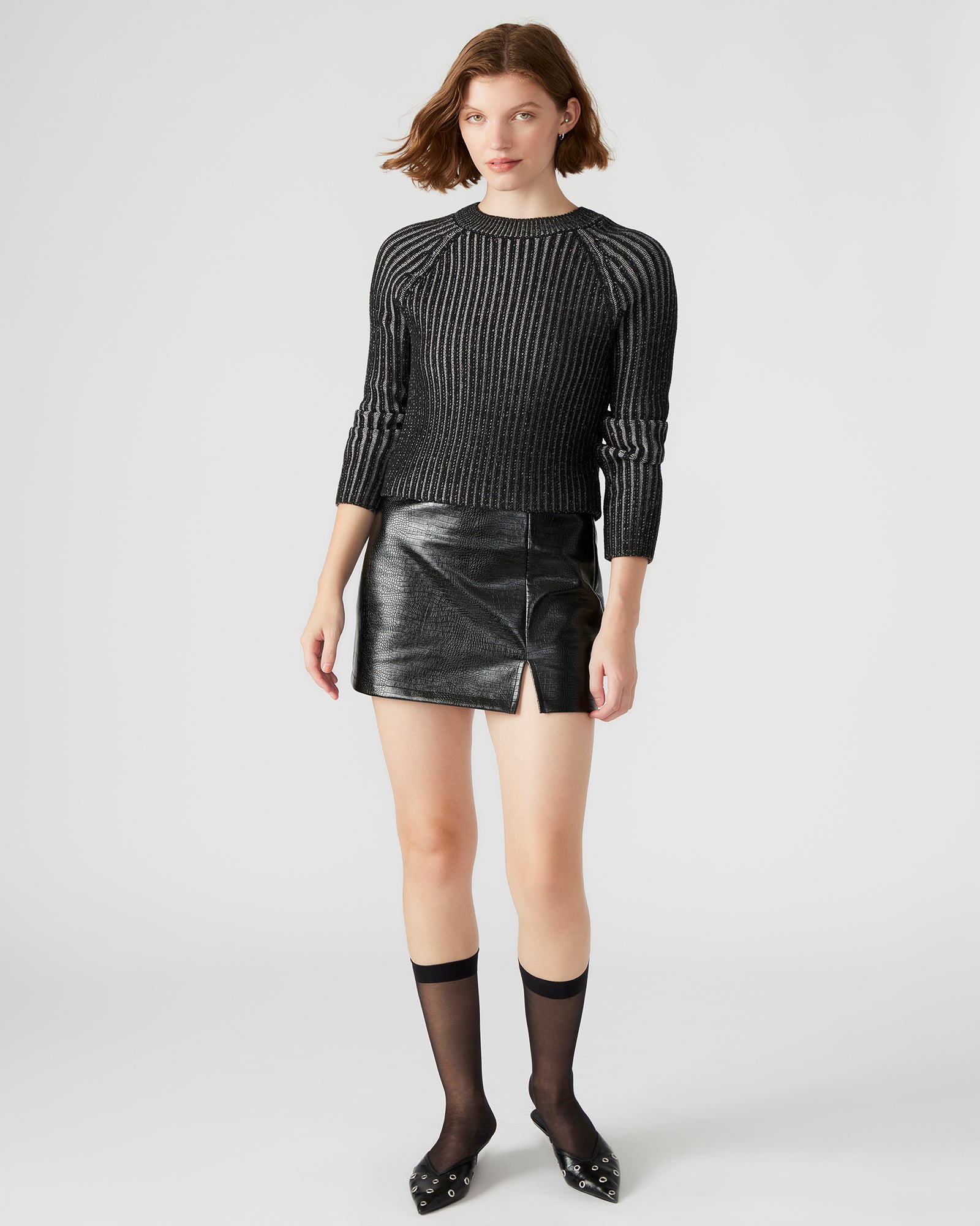 Model wearing the Cameron crocodile print mini skirt with side slit, paired with a sleek top.