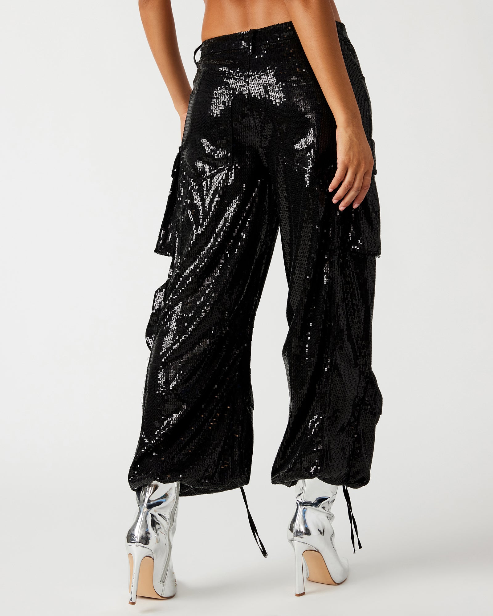 Close-up of sequin pant texture and cargo pockets with extended zipper pulls.