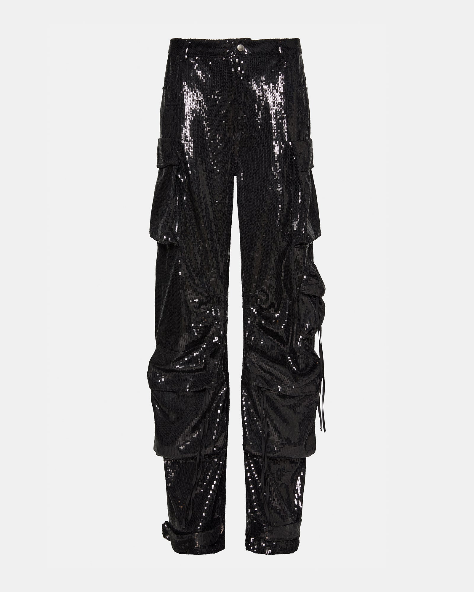 Side view of black cargo pants styled with ankle strap detail in urban Chicago setting.