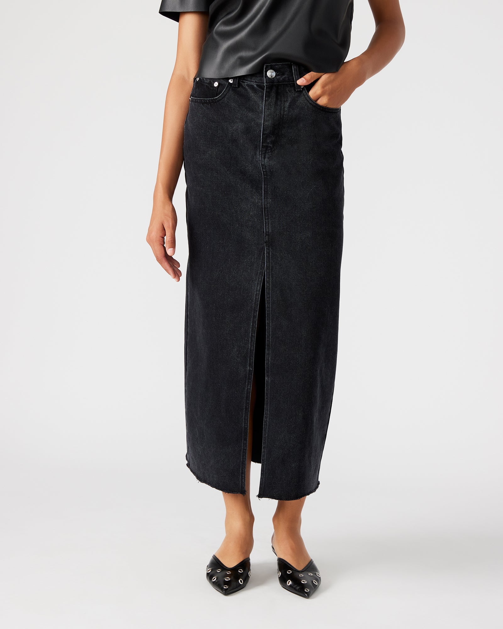 Side view of the black skirt highlighting the raw hem detail.