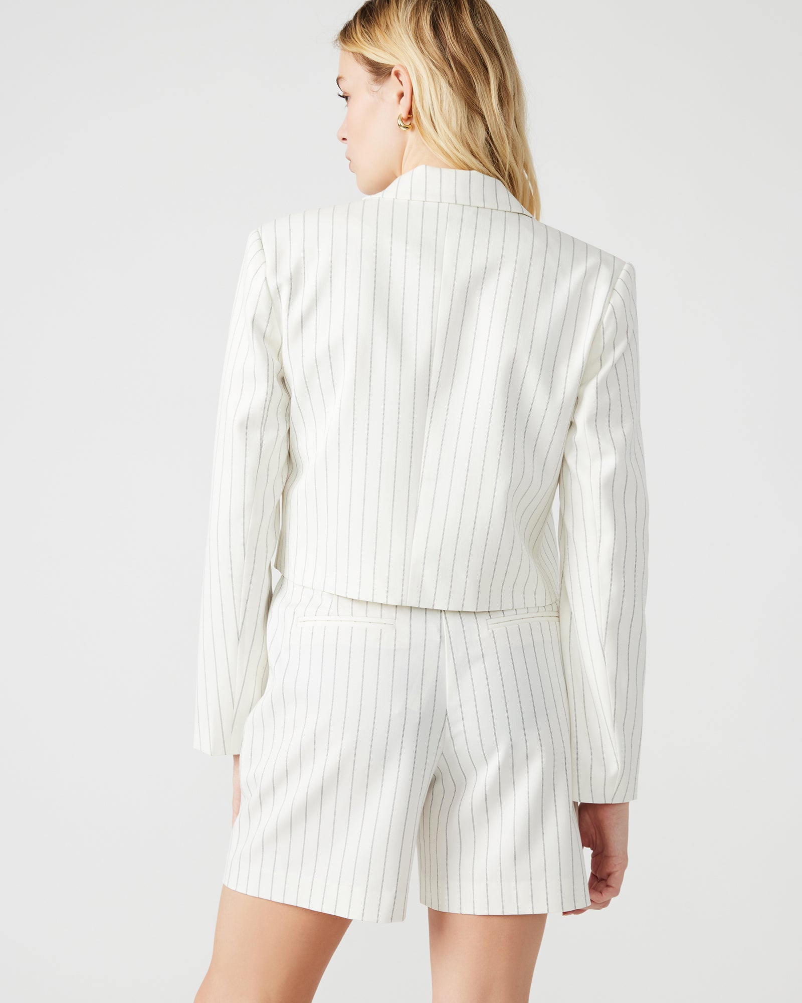 Front view of cropped black and white blazer on model