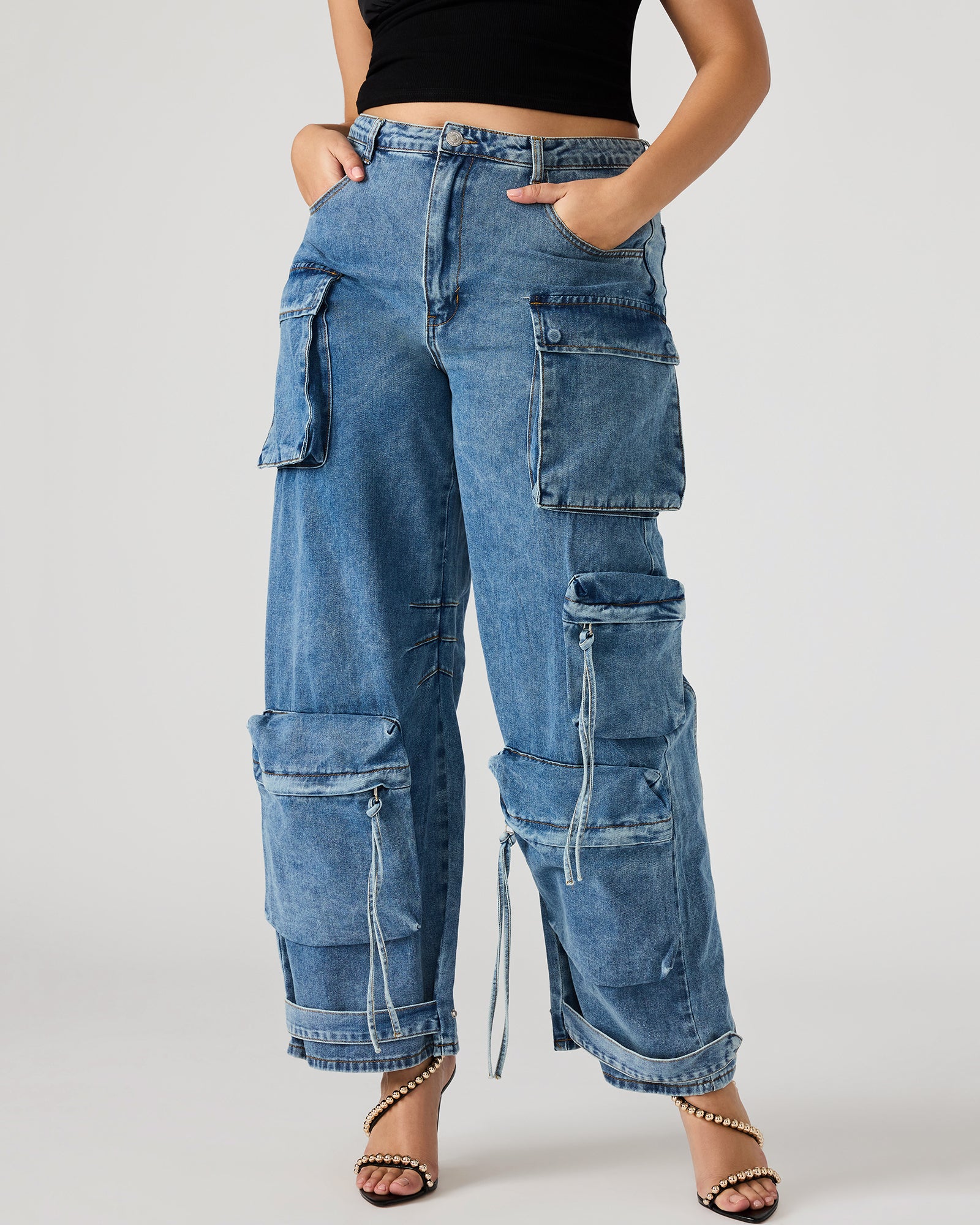 Close-up of adjustable ankle straps on medium denim cargo pants.